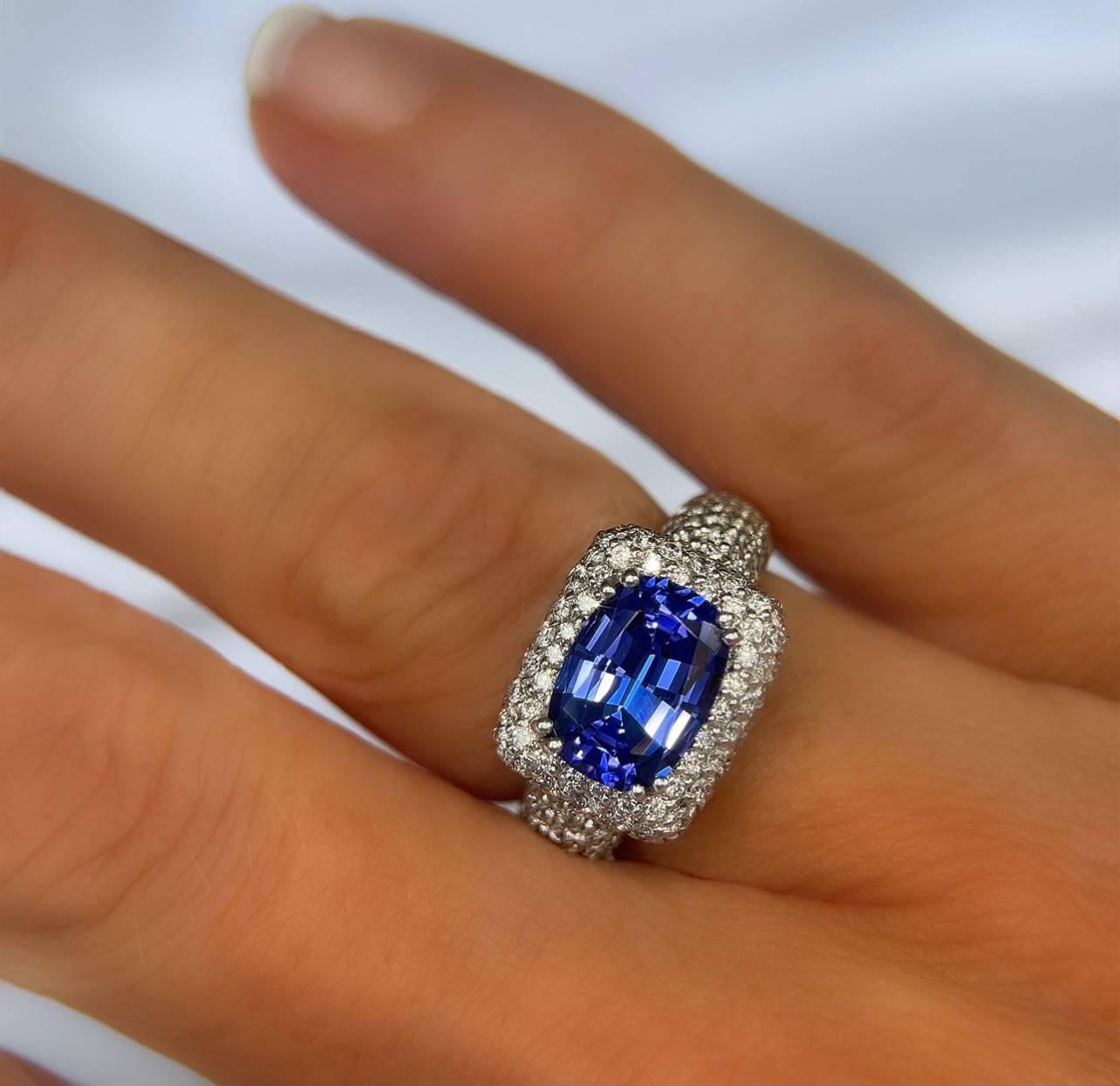 Spectacular vivid color! This 2.45 carat cushion cut tanzanite is absolutely stunning. The 1.18 cttw F color, VVS clarity diamonds highlight the beautiful tanzanite. This is set in 18Kt white gold weighing 9.30 grams.  This ring is signed SGJ and