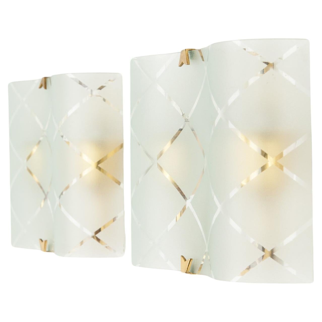 A lovely and elegant pair of modernist glass wall lights with brass details. The soft wavy glass, with an etched diagonal pattern, is held by a curved brass bracket. Beautiful Italian craftsmanship and attention to detail is visible throughout,