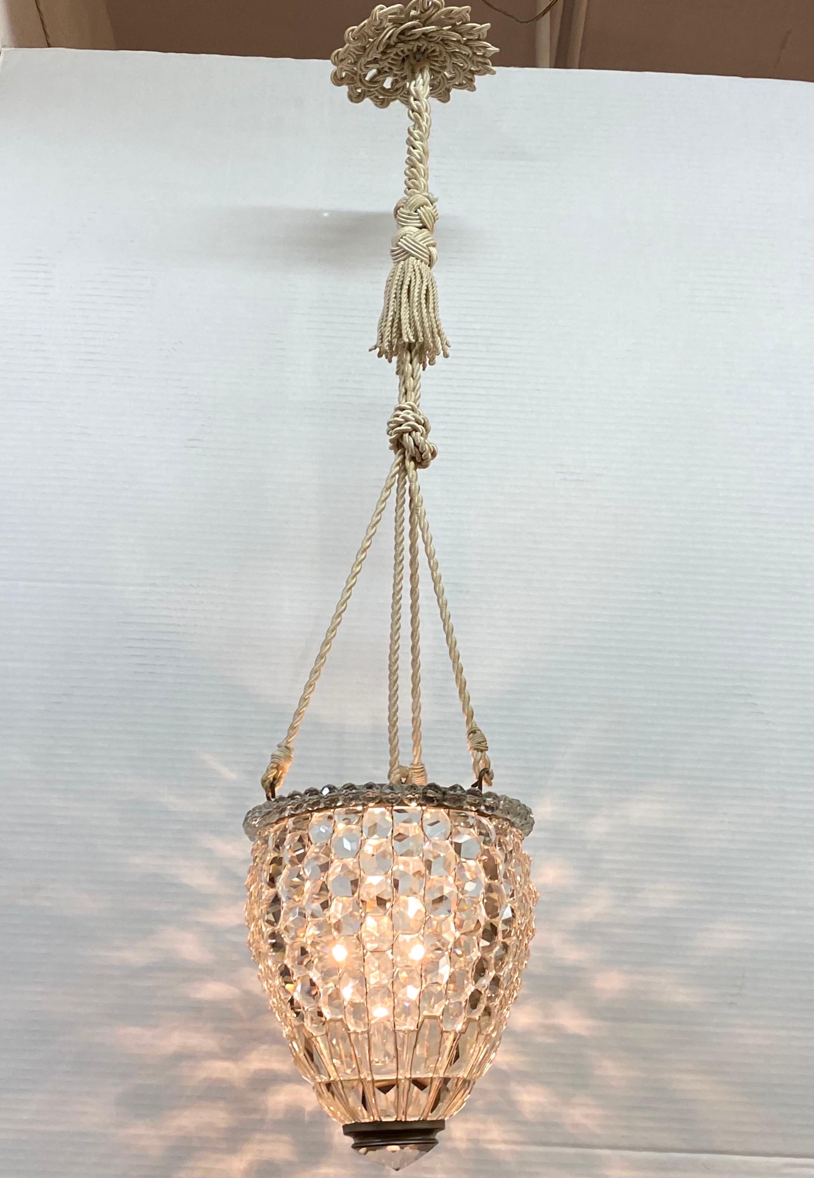 A unique and beautiful Italian faceted lantern style pendant light circa 1950. The shade is a lovely pear shape consisting of intricately wired large faceted crystals with a metal rim top and bottom. The top rim is ornamented with faceted crystal