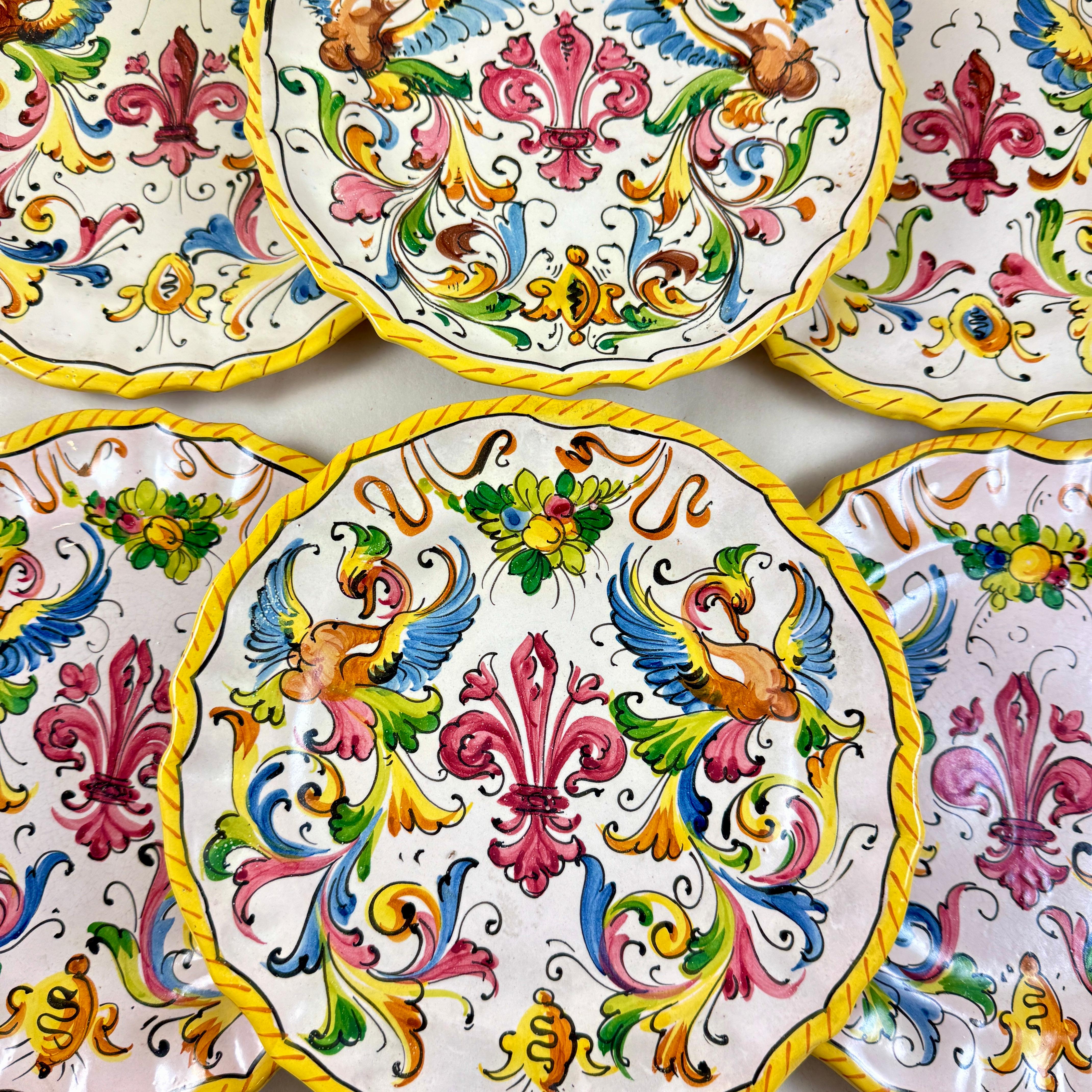 A charming set of six hand painted earthenware plates in the Italian la campagna  country style, circa 1940-1950.

Brightly painted with a central deep red Fleur-de-lis surrounded by a garland of fruit and scrolling in blue, green, red and yellow.