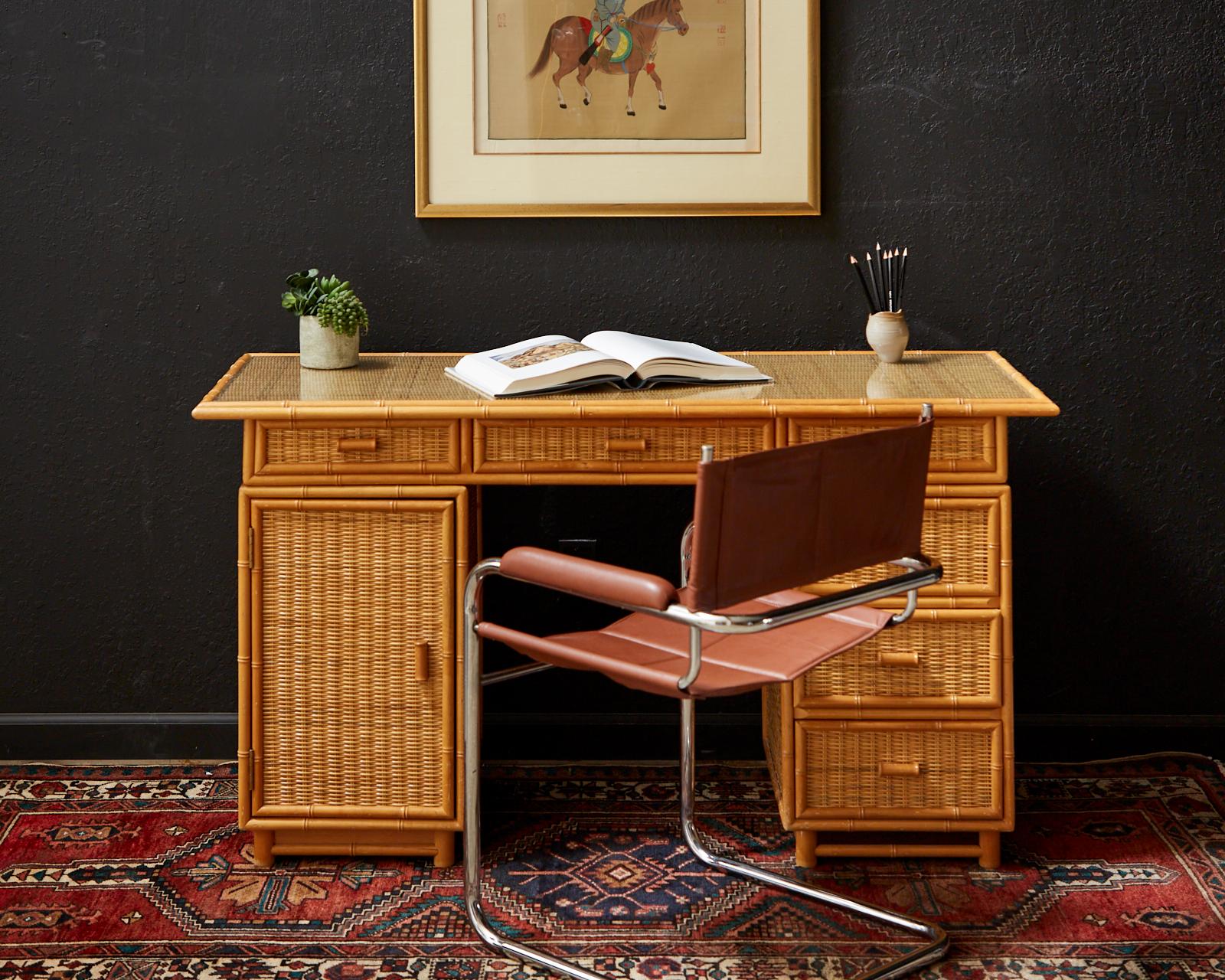 Mid-Century Modern Italian pedestal style writing table or desk. Crafted in the Campaign style with a removable top section and two pedestals. The case features decorative carved faux bamboo trim and wicker rattan inset. The top of the desk has a