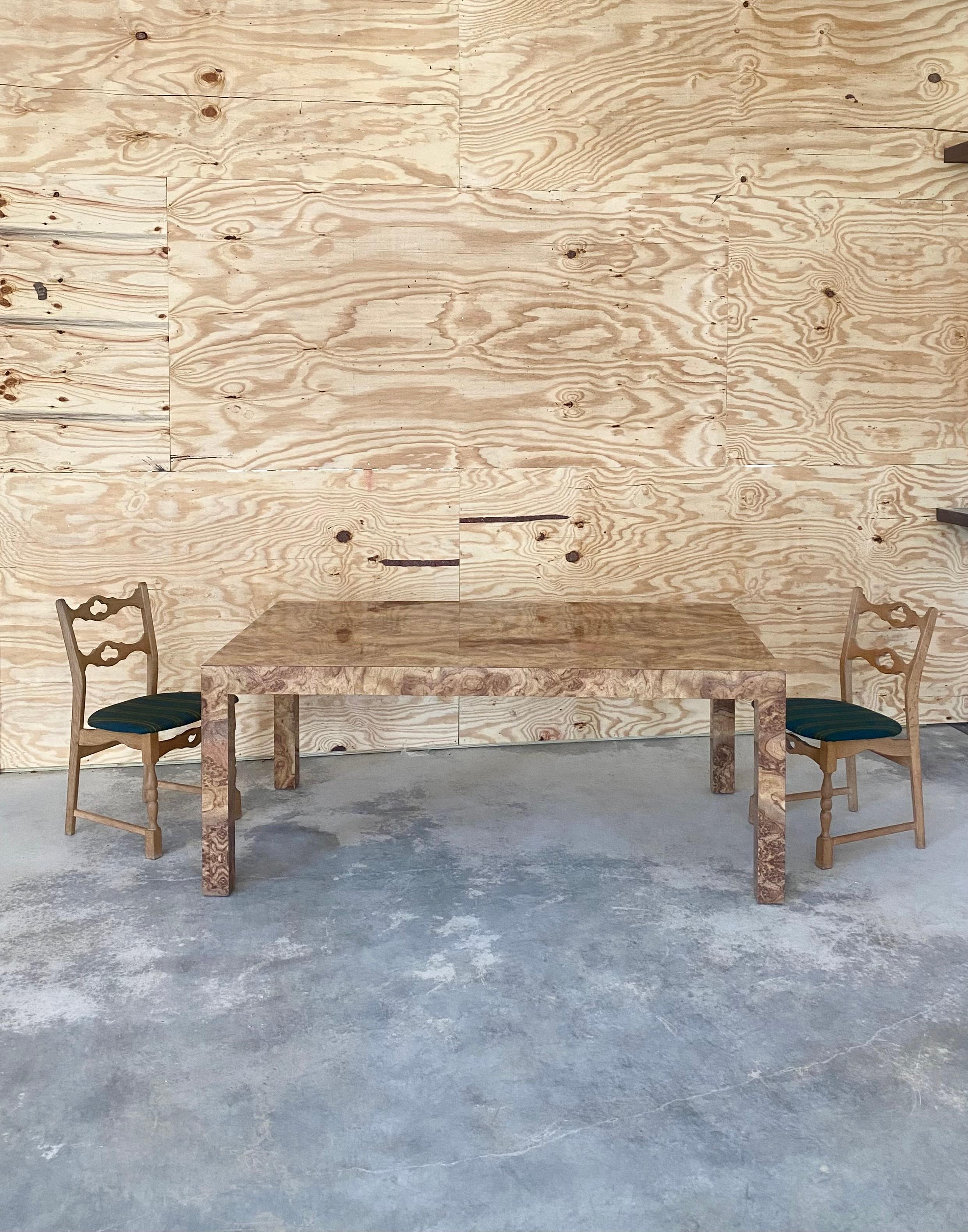 This striking, late 1970s Italian dining table features a rich faux burl wood laminate top with a seamless, uninterrupted grain pattern that gives the illusion of real burlwood across the top surface. Its sleek lines and bold presence exemplify