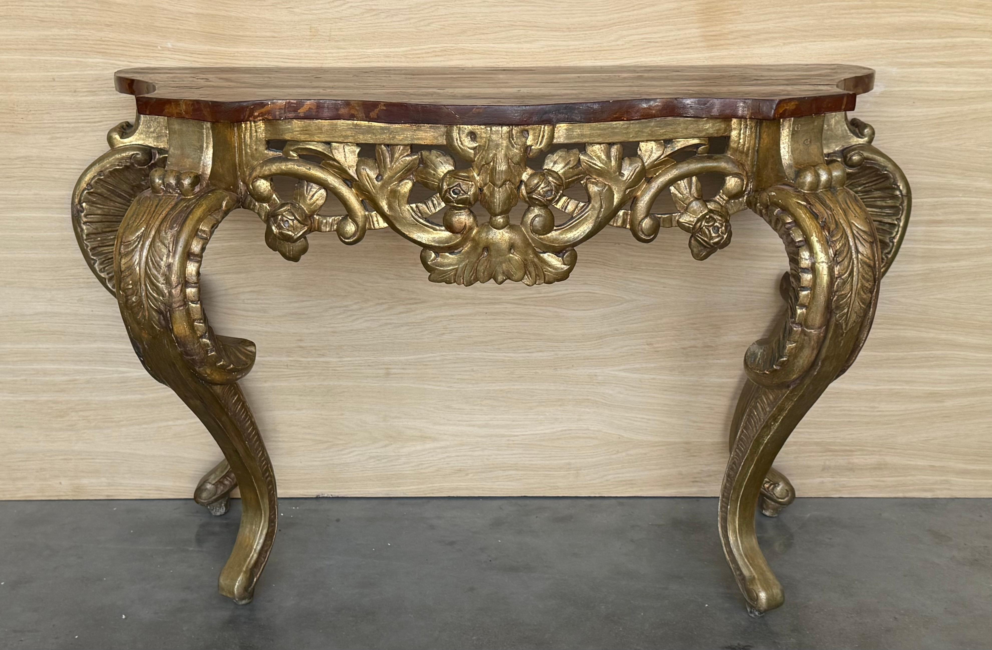 Italian Faux marbleized four legs console with a gilded lambs tongue egg and dart border, gilded scrolled acanthus legs, exterior and interior floral medallions, and resting on scrolled feet with fruit and berry motif, Early 19th century.
