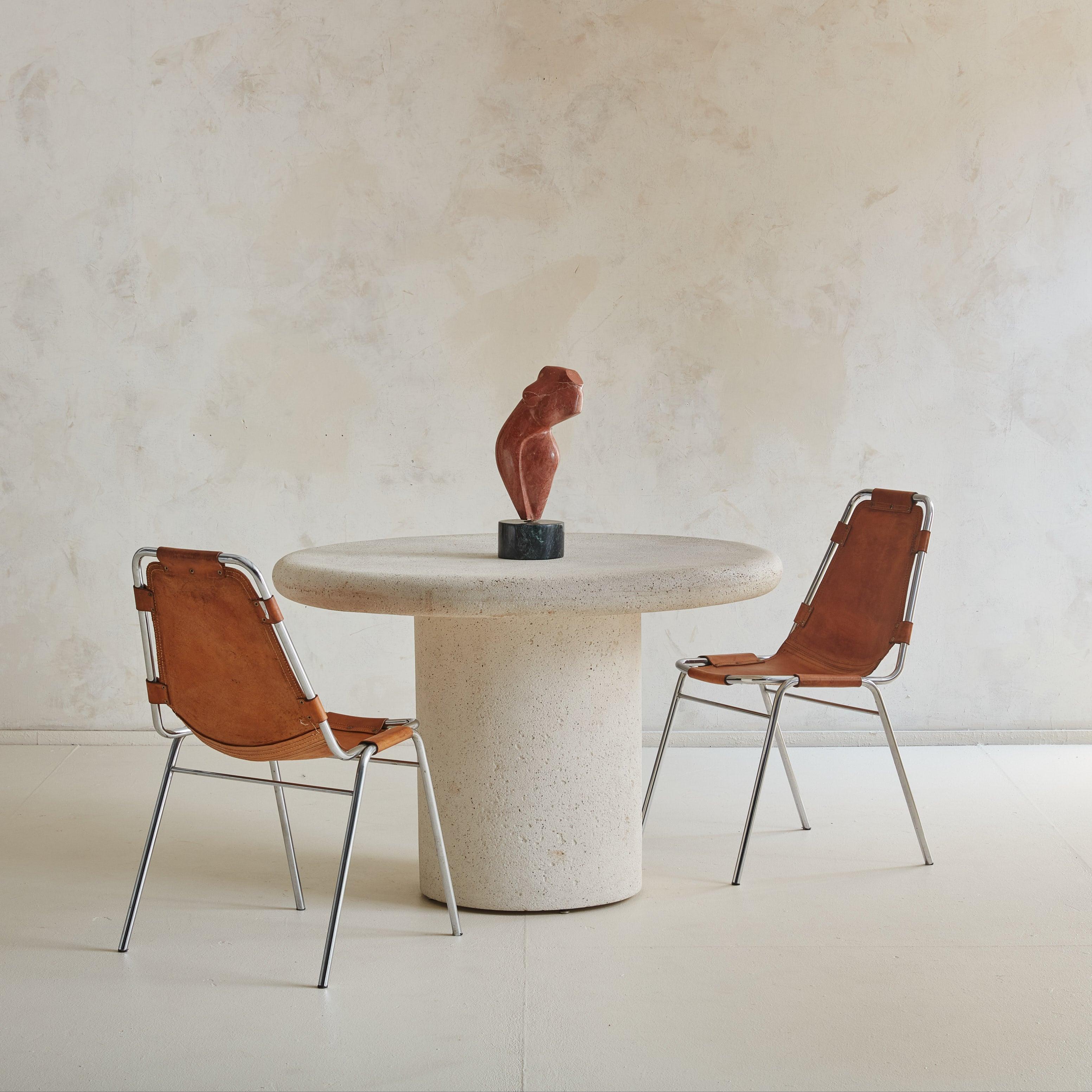 Cette table italienne des années 1980 possède le poids visuel et la présence du travertin, mais elle est en fait fabriquée en plâtre. De conception minimaliste, le plateau à bord arrondi et le socle cylindrique sont accentués par leur surface