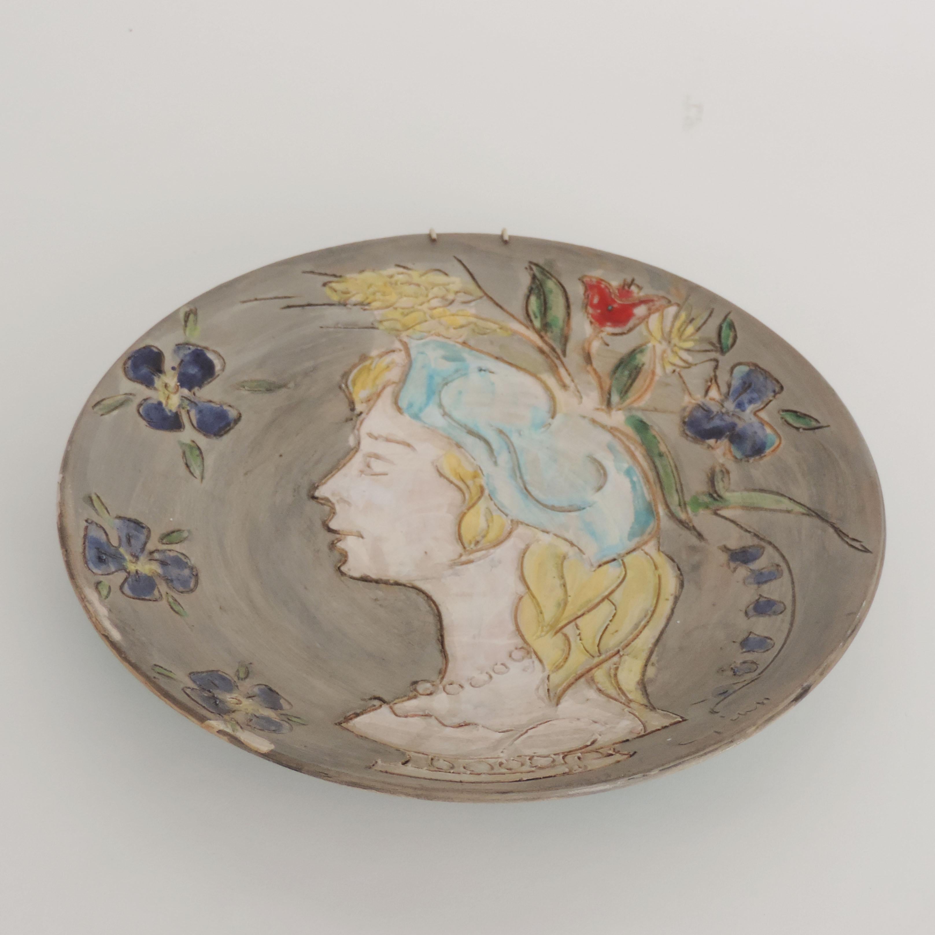 Splendid Italian Figurative engraved Earthenware Wall Plate, 
Woman bust with flowers on her head 
Illegible Signature.
Italy 1950s.