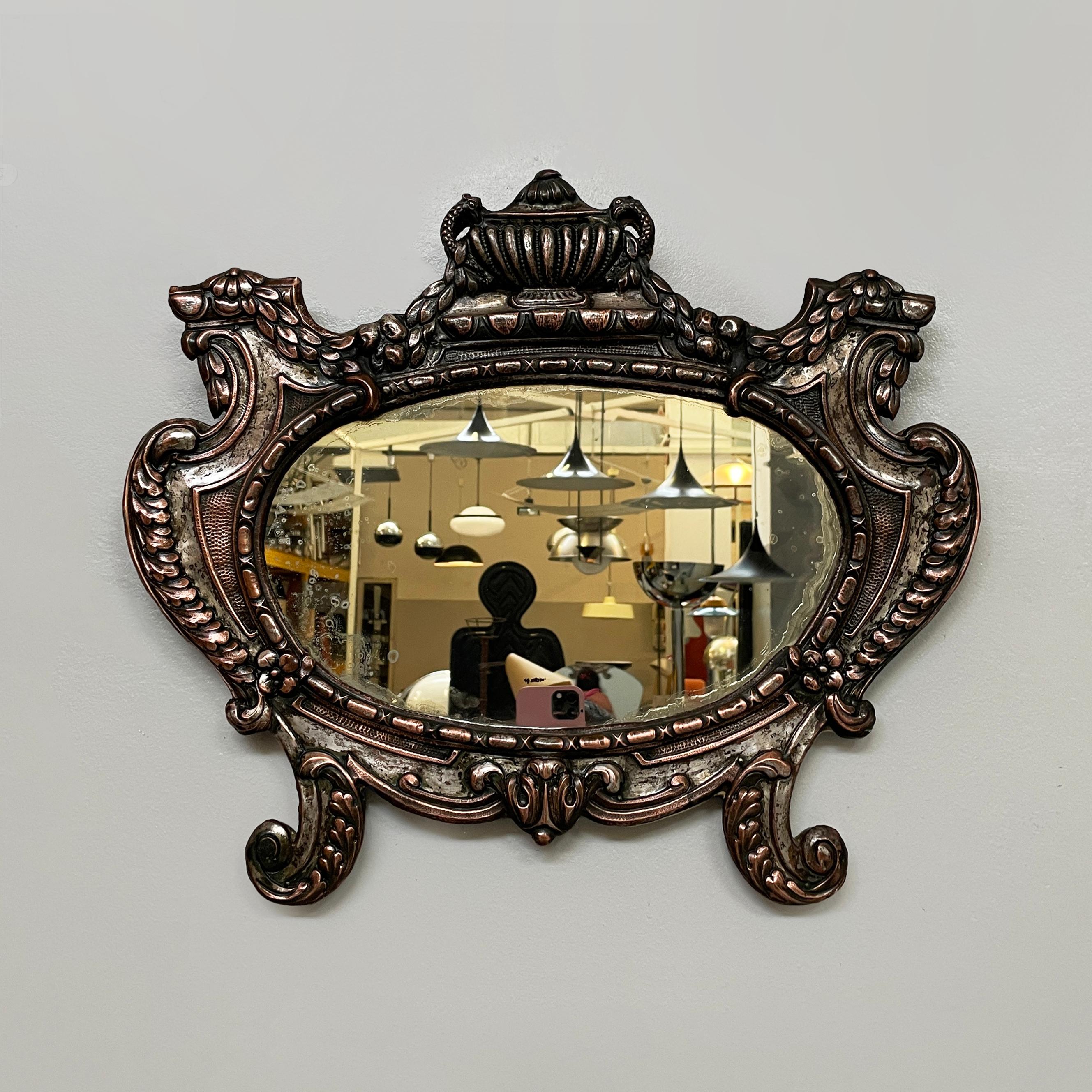 Specchio da parete ovale italiano finemente lavorato in rame argentato, inizio '900
Elegante specchio ovale da parete vintage con cornice finemente lavorata in rame argentato. I soggetti del profilo sono riccioli e motivi di foglie.  La struttura