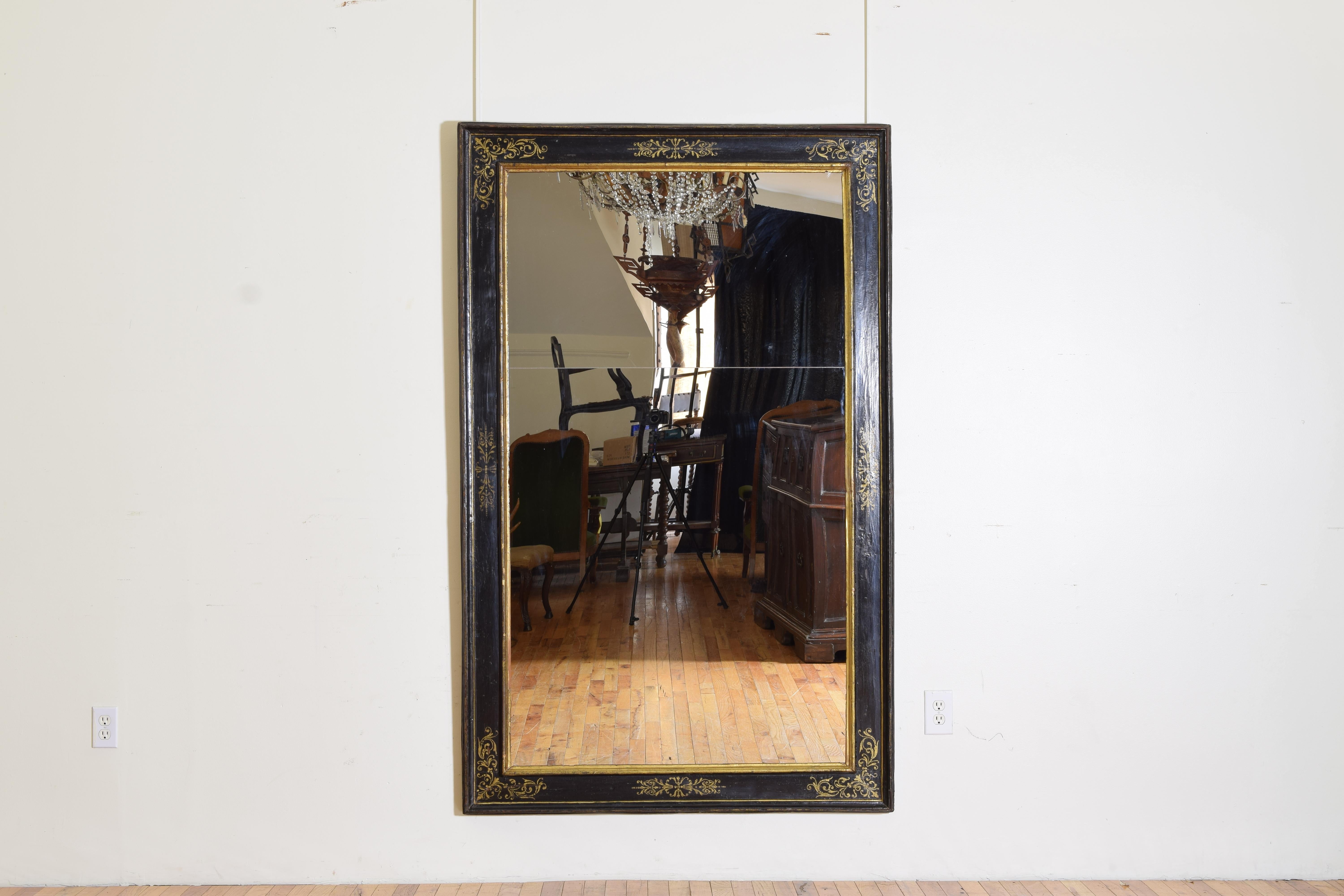 constructed of pinewood this frame is completely ebonized and then decorated in stencil and free hand gilding, with raised outer moldings, the separate mirrorplates are modern.