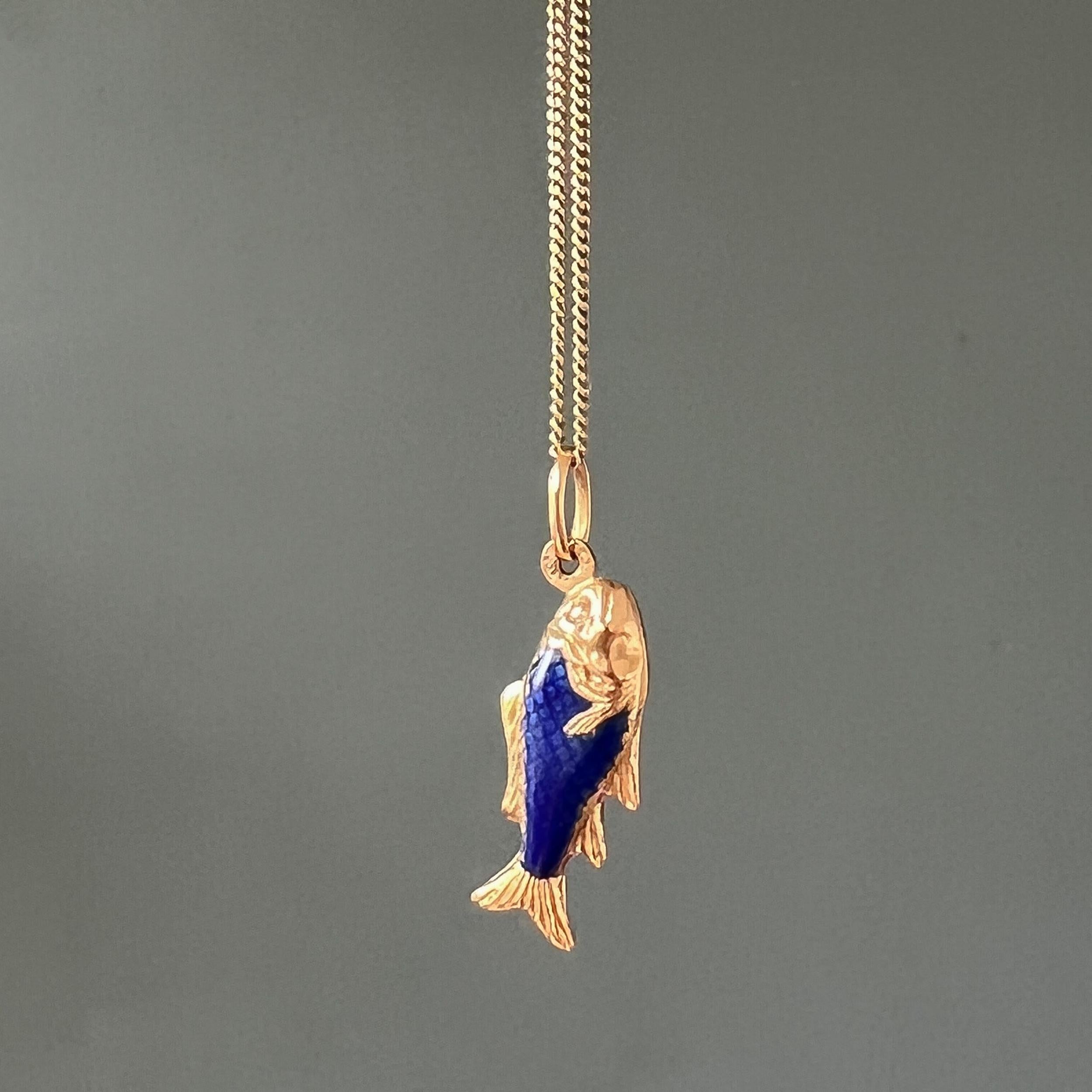 A vintage Italian gold fish charm pendant created with a blue enameled body. The fish is beautifully detailed and created with a great royal blue scaly skin. Designed in 18 karat yellow gold, the body is detailed with raised work and finished with