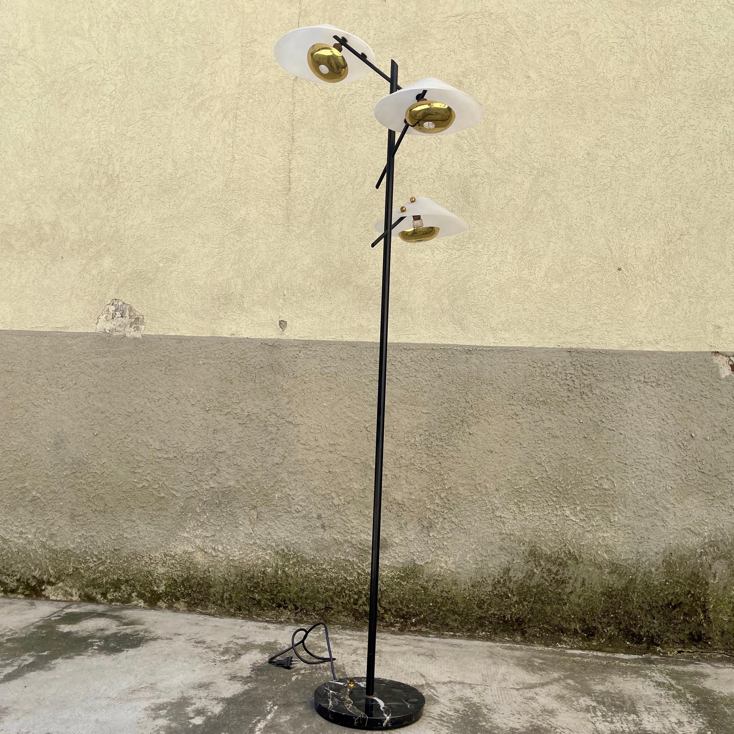 Floor lamp with marble base and brass foot control, consisting of a black lacquered stem and three arms carrying frosted perspex caps.
