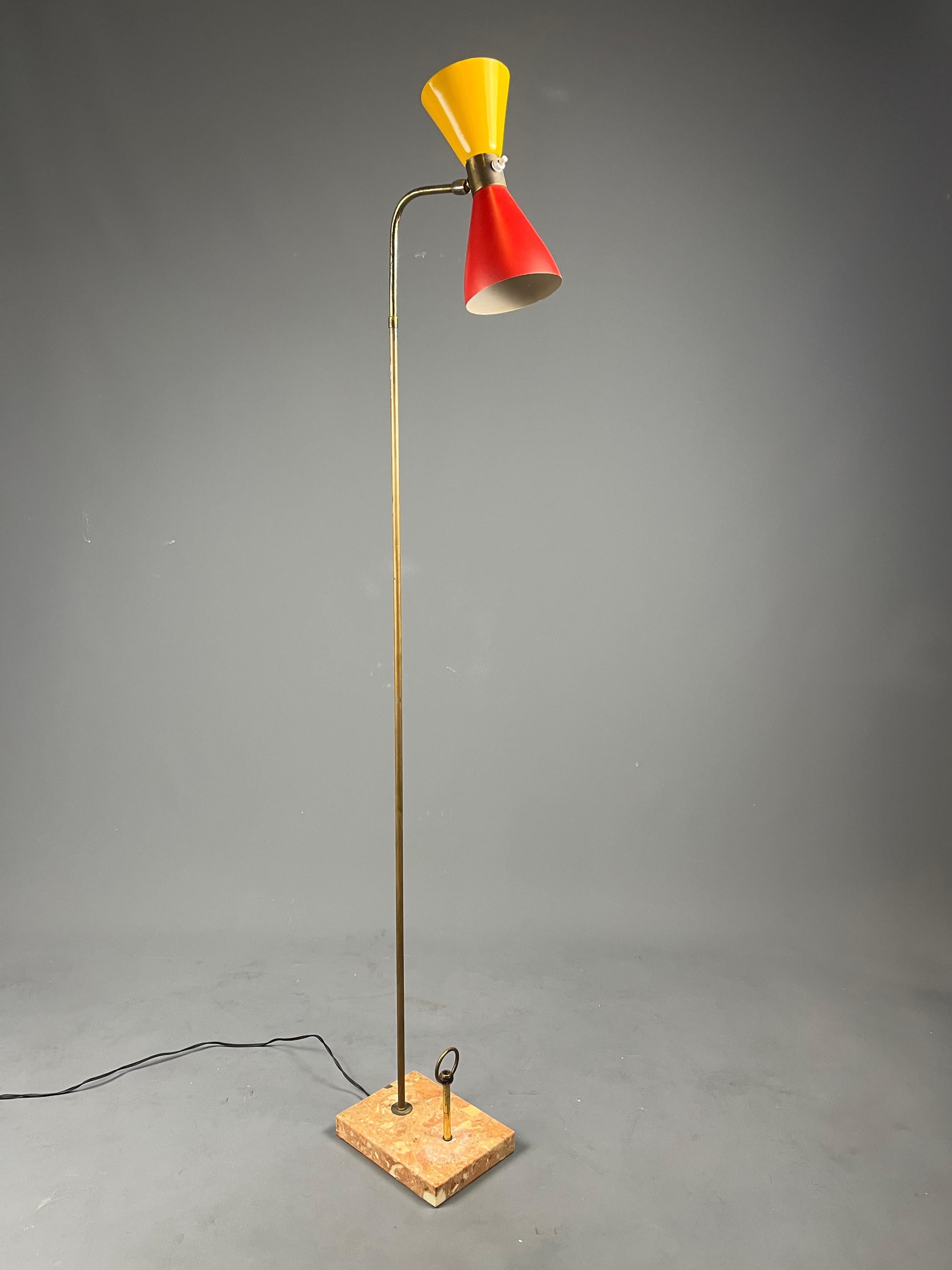 Elegant Italian floor lamp from the 1950s.
This model is distinguished by its double cone shade—red for the lower part and yellow for the upper part—mounted on a thin brass stem. The shade is movable and slightly adjustable, and the light is