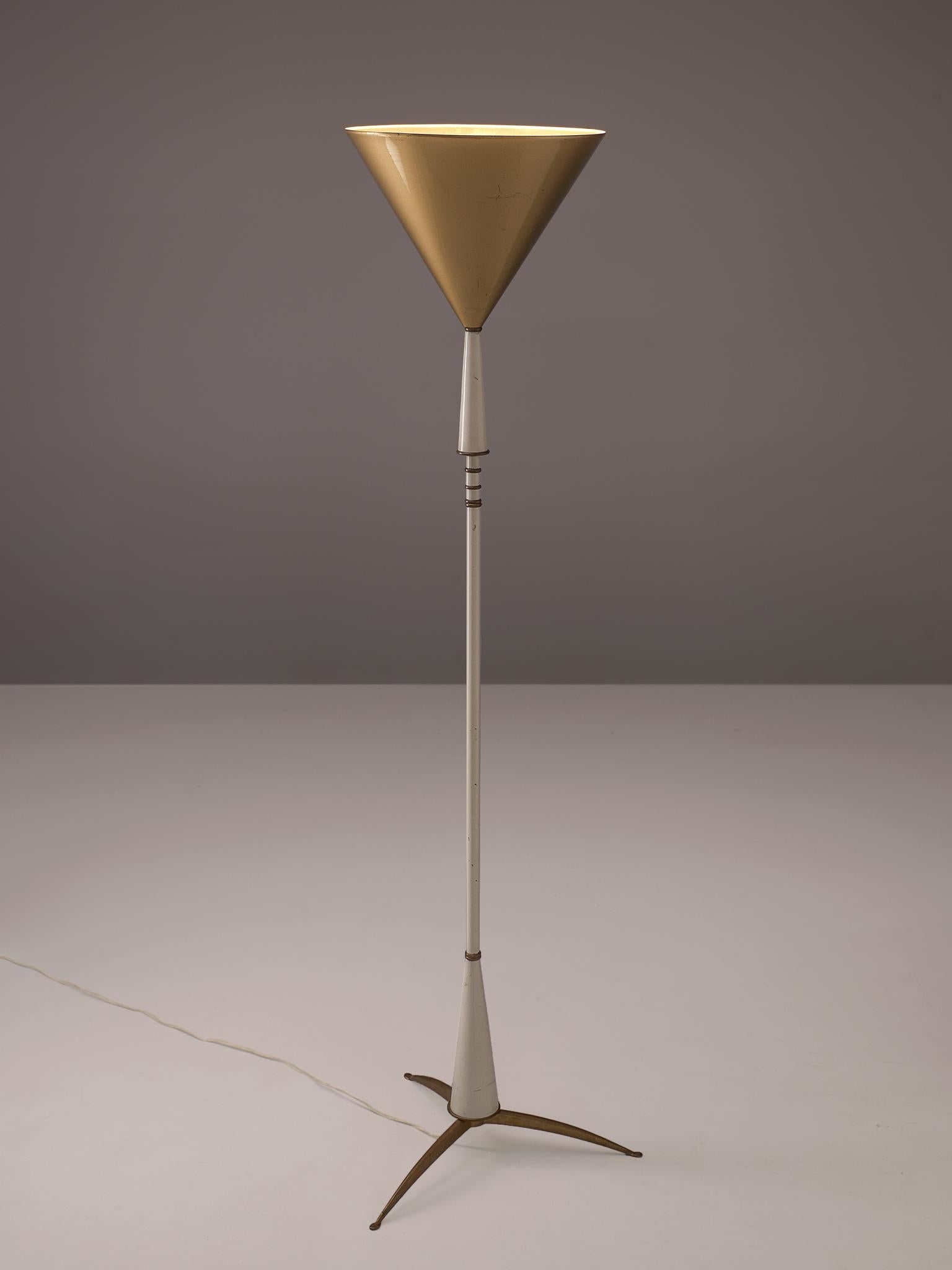 Floor lamp, metal and brass, Italy, 1960s.

Elegant floorlamp with tripod foot in brass. Consisting of a white lacquered metal base that is finished with brass rings. The base holds a large, cone shaped shade that has a golden color lacquer on the
