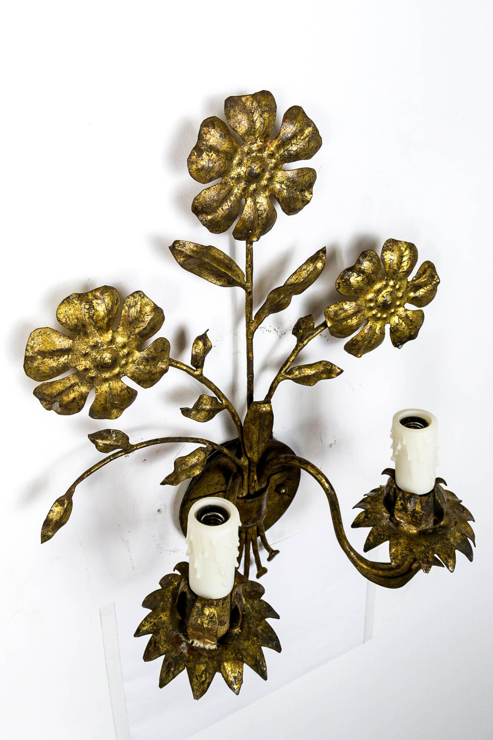 These beautifully shaped, double candelabra light fixtures of gilded metal sprouting three flowers with leaf accents and decorative stems. Made in Italy in the 1930s. Newly rewired with poly-beeswax candle covers. Measures: 12.5
