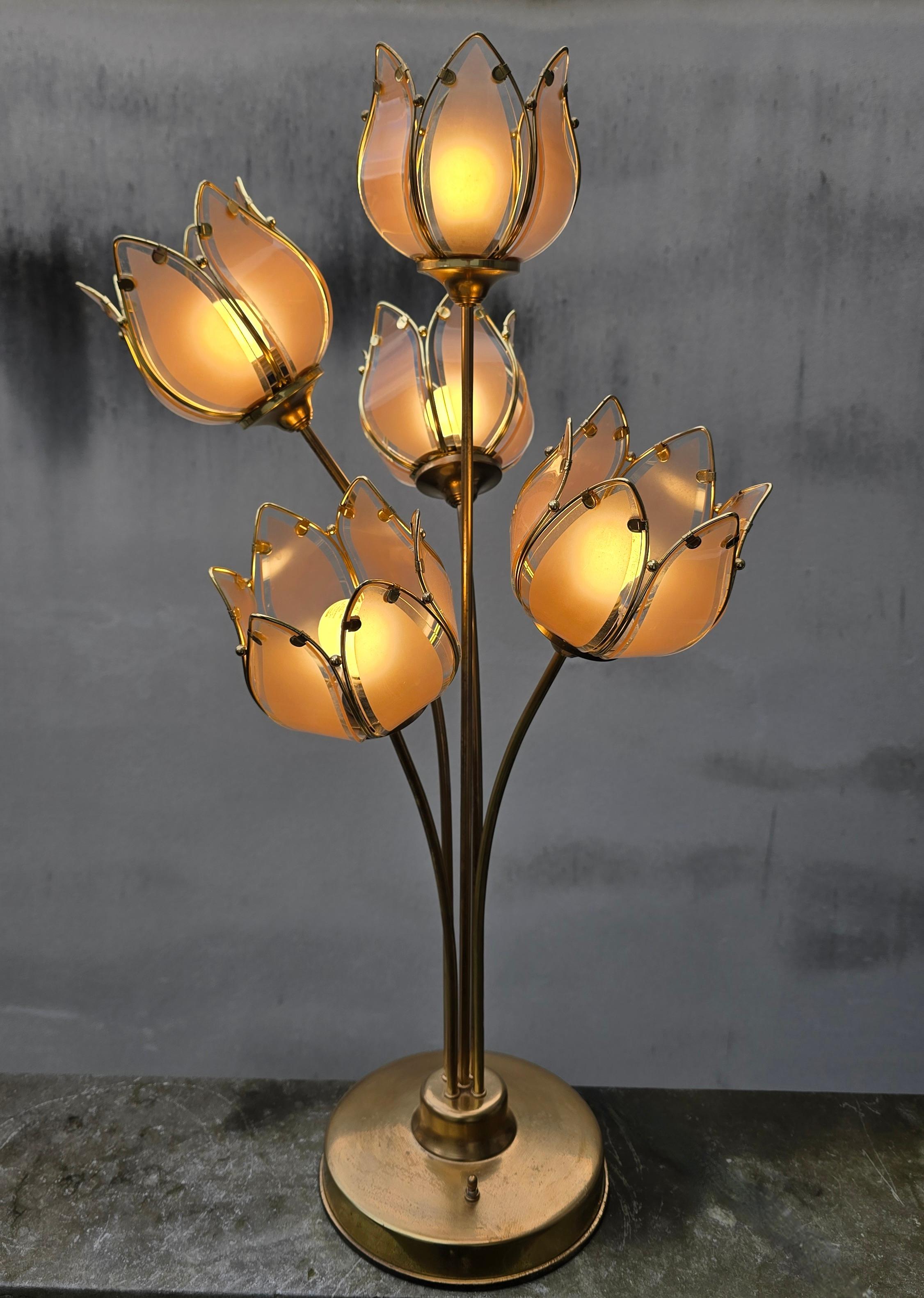 Rara lámpara de sobremesa italiana de los años 70 con cinco esculturales tulipas de cristal tintado de rosa, enmarcadas en latón. La lámpara ofrece tres ajustes de luz y un hermoso resplandor cálido. Una refinada pieza de la Regencia de Hollywood