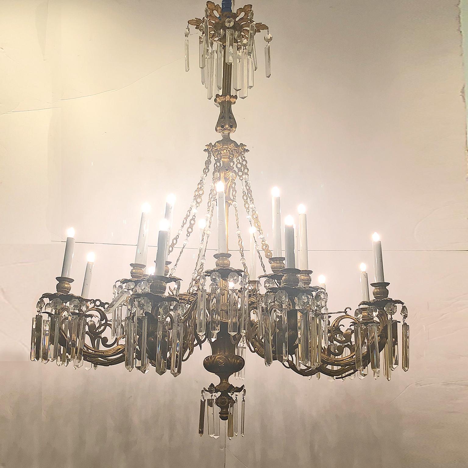 Large 16-light gold bronze chandelier with candles. Complete with cut crystal pendants. Very elegant, in excellent condition with new electrical system. The shape and the materials used make it clear that the chandelier is certainly of Italian