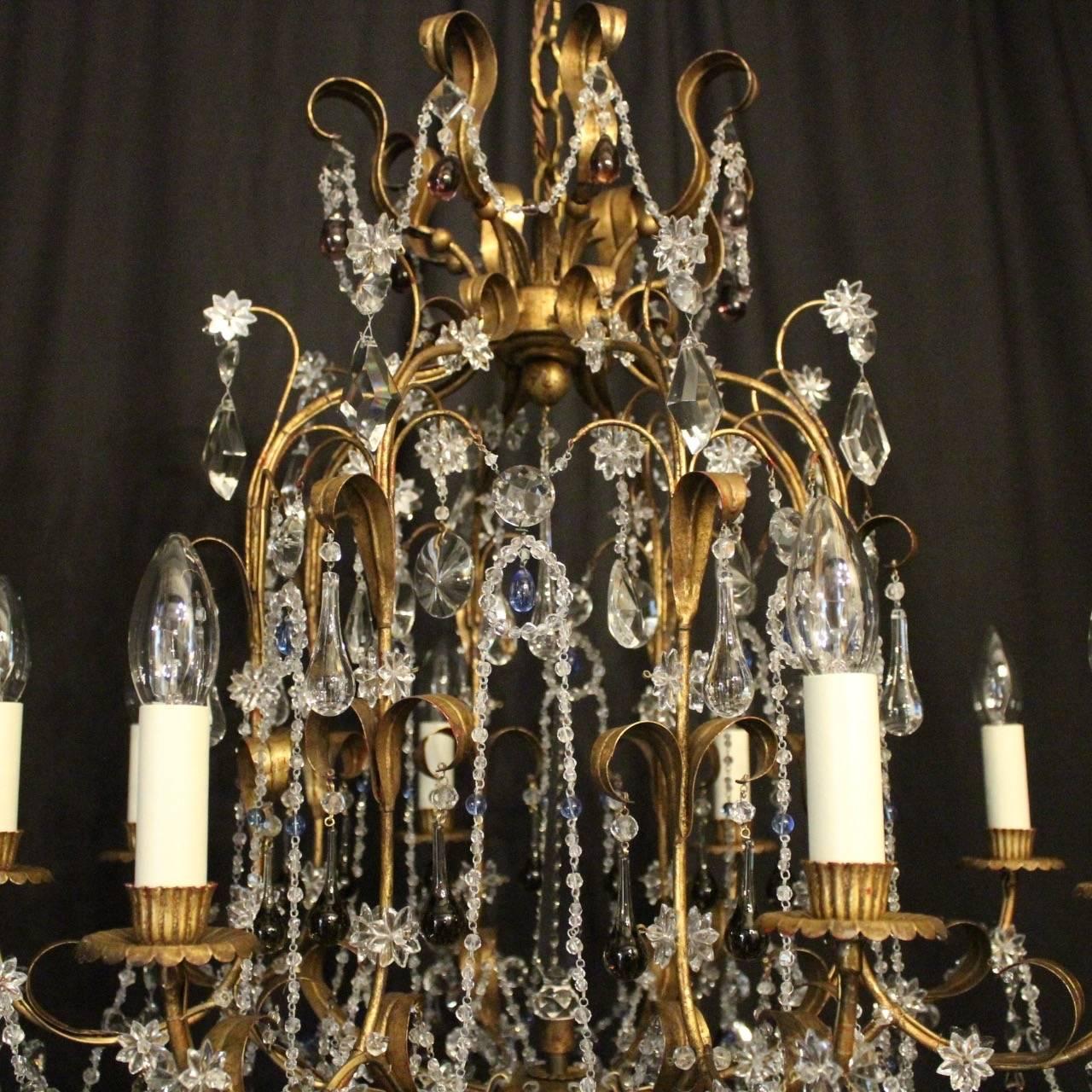 A decorative Italian gilt and crystal eight-Light birdcage form antique chandelier, the leaf scrolling arms with circular leaf bobeche drip pans and reeded candle sconces, issuing from an cage form interior with large prismatic spike and ornate