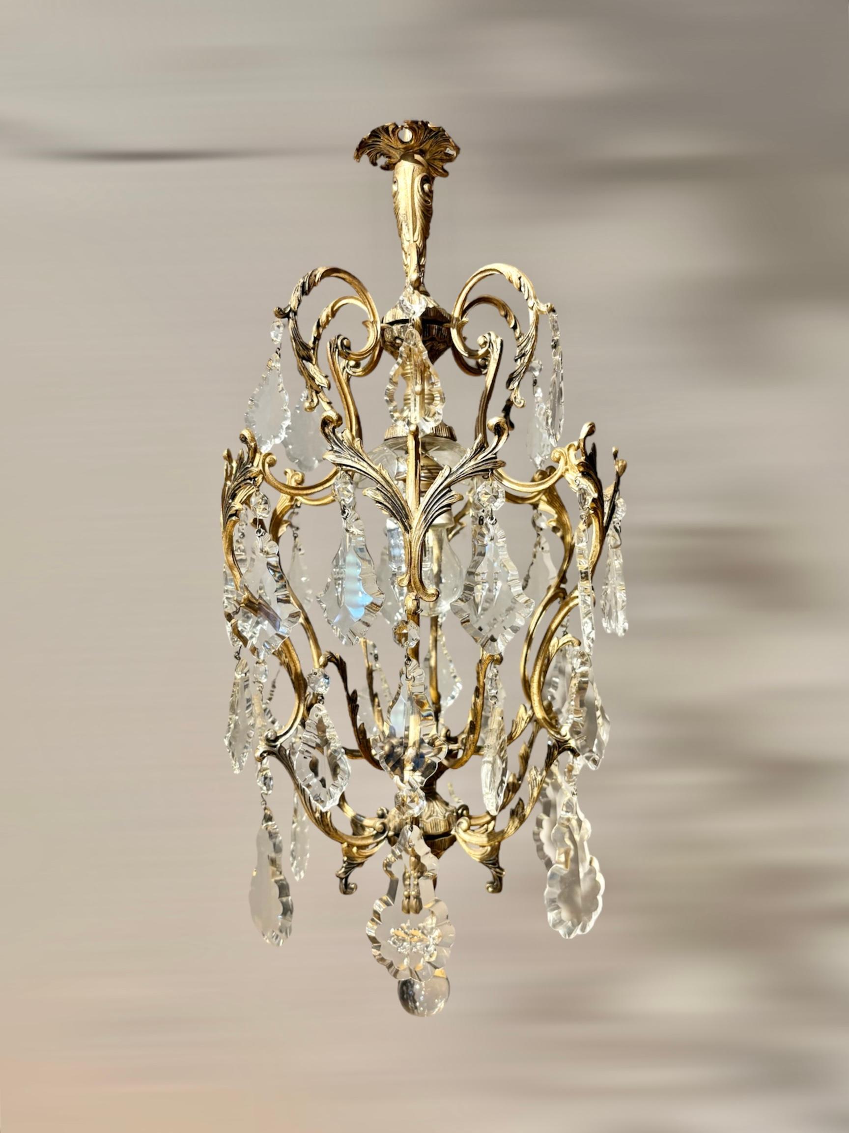 Ein atemberaubender italienischer Kronleuchter aus den 1950er Jahren, der im französischen Rokoko-Stil gefertigt wurde. Er besteht aus fein gegossenem, vergoldetem Messing (Ormolu) und hat eine elegante Käfigform, die mit funkelnden böhmischen