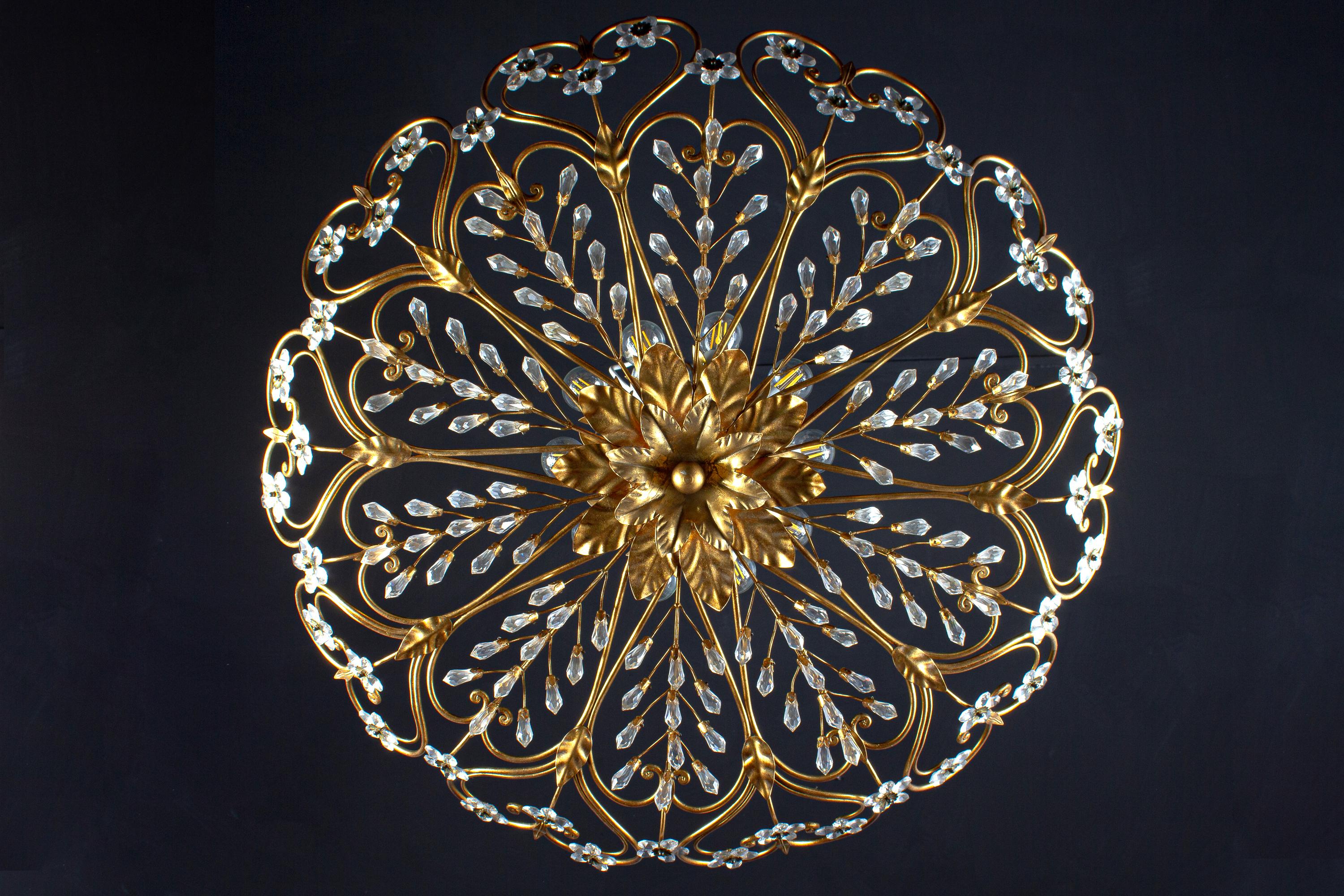 A stunning flush mount with amazing gilt acanthus leaf and glass blossoms each blossom is made of 6 glass petals in diamond cut and a Cascade of crystal leaves.
The light is wired and in full working order, 10 bulb holders, E14 small screw