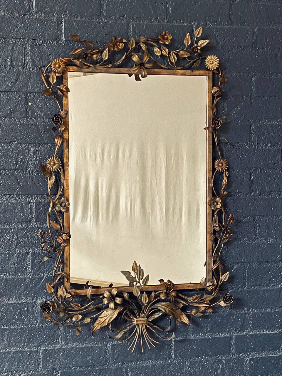 Condition: Original Vintage Condition
Materials: Gilt Metal, Original Glass Mirror
Style: Italian Florentine 

This Italian Florentine gilt mirror, dating to the 1940s, features an ornate frame of gilt metal adorned with delicate floral and ribbon