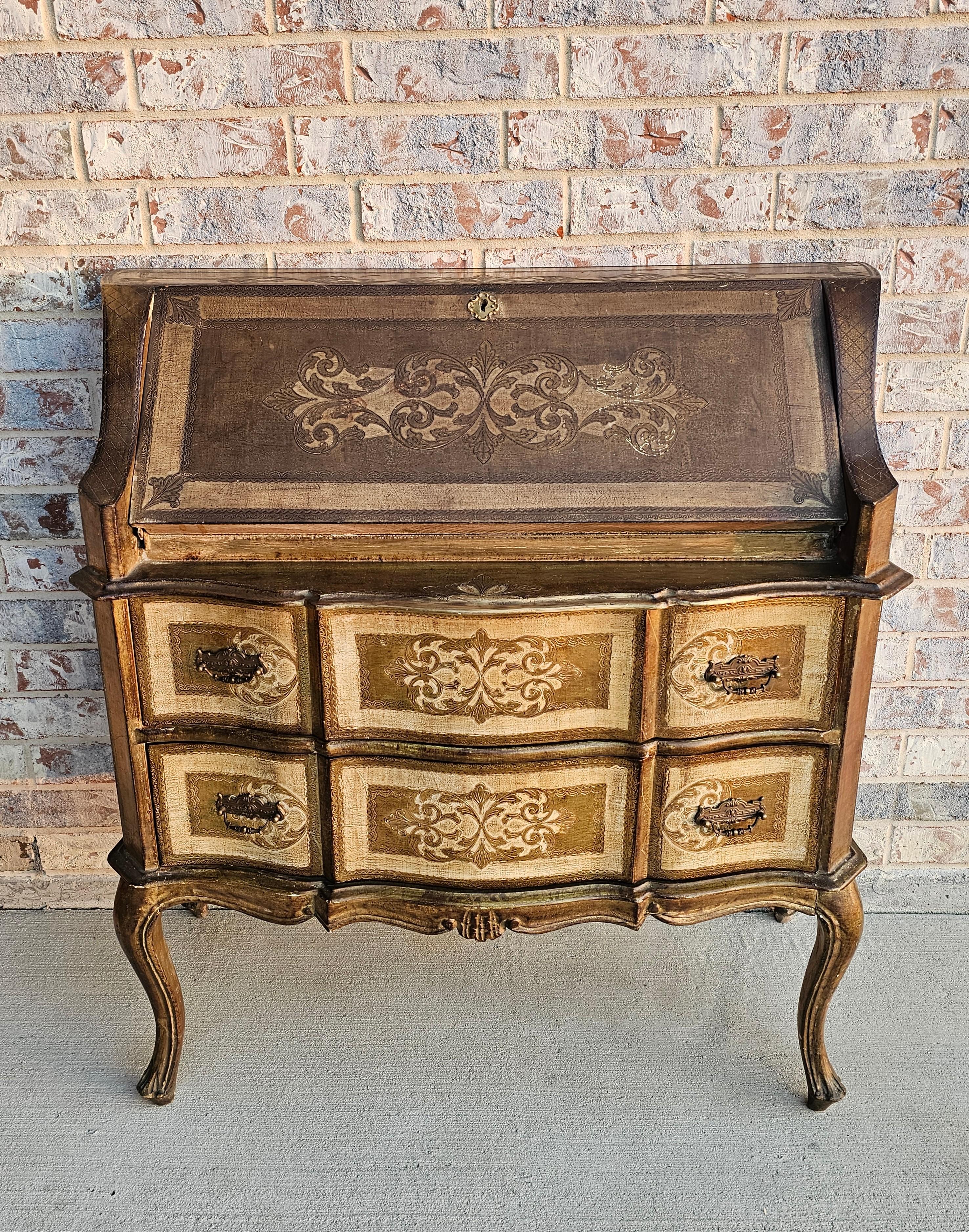 Bureau à plateau incliné en bois sculpté, peint à la crème et doré, de Florentine, avec une patine d'ancienneté sombre et chaude sur l'ensemble.

Fabriqué à Florence, en Italie, vers avant 1940, exécuté dans le goût baroque vénitien influencé par le