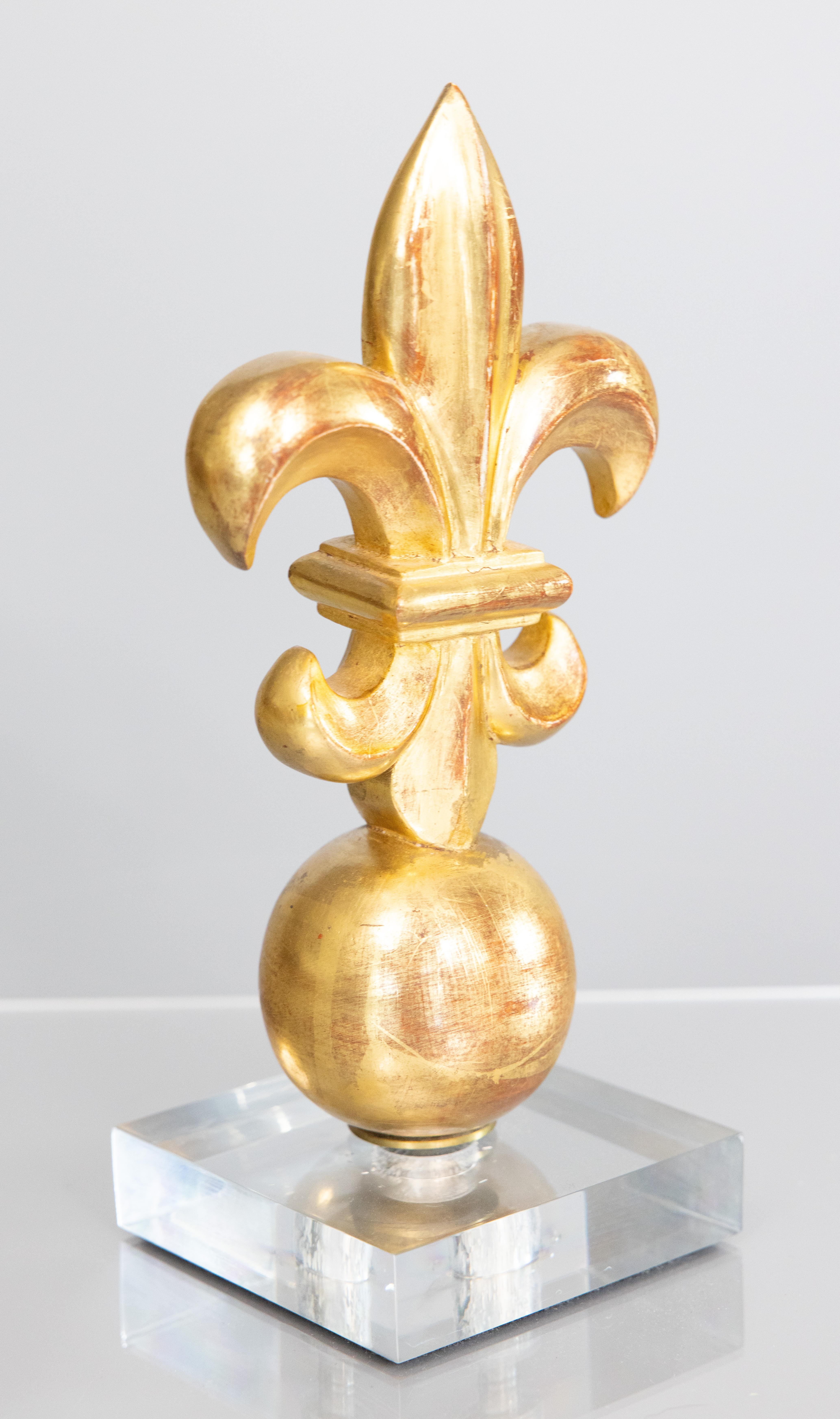 Fabulosa escultura flor de lis florentina italiana vintage de los años 50 de madera dorada montada sobre una base de lucita. Esta elegante escultura puede utilizarse como pisapapeles, sujetalibros o pieza decorativa de acento en cualquier