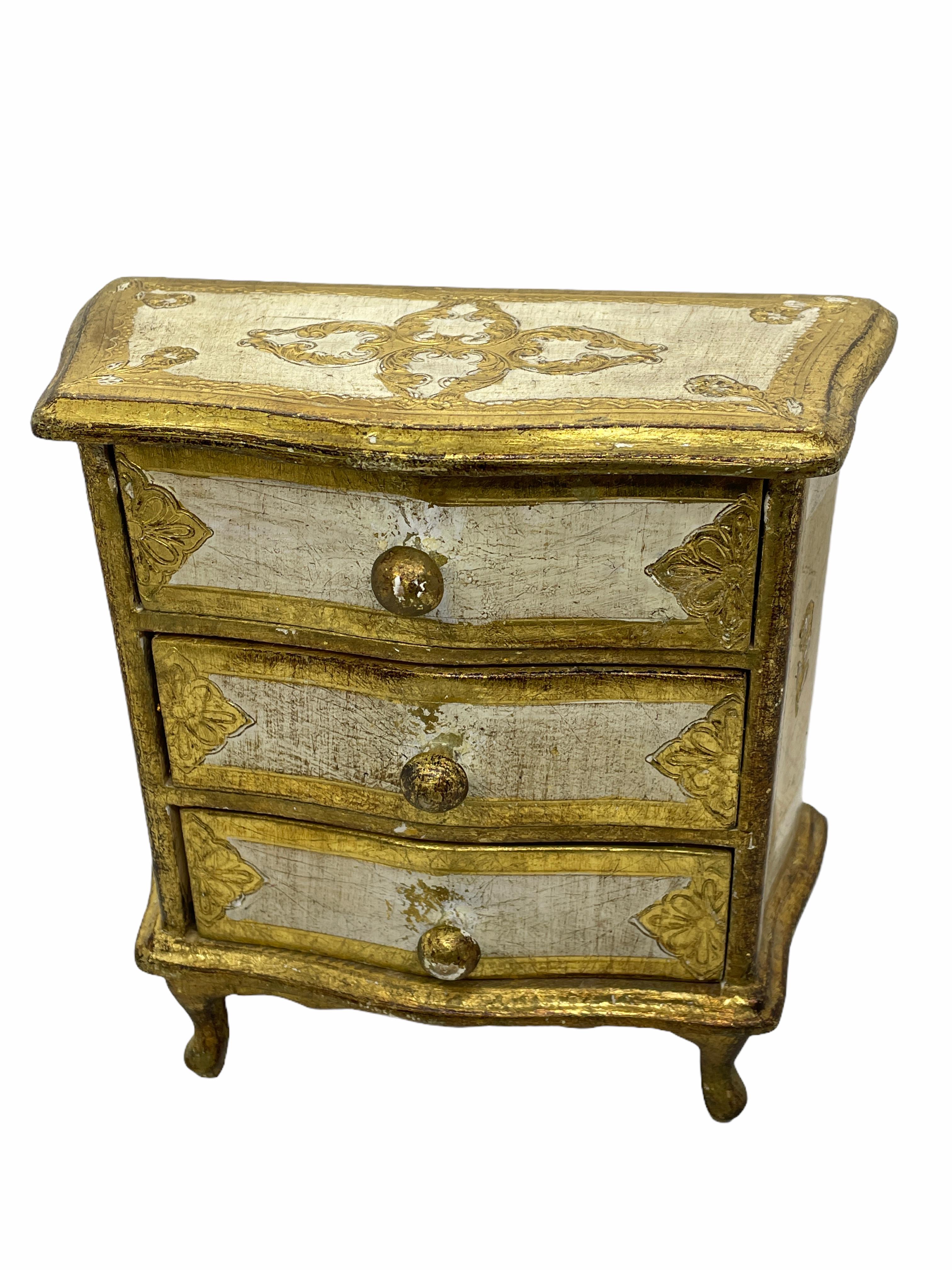 Offered is an absolutely stunning, 1950s Italian giltwood jewelry box in the design of a chest of drawers. Minor patina and paint lost gives this piece a classy statement.