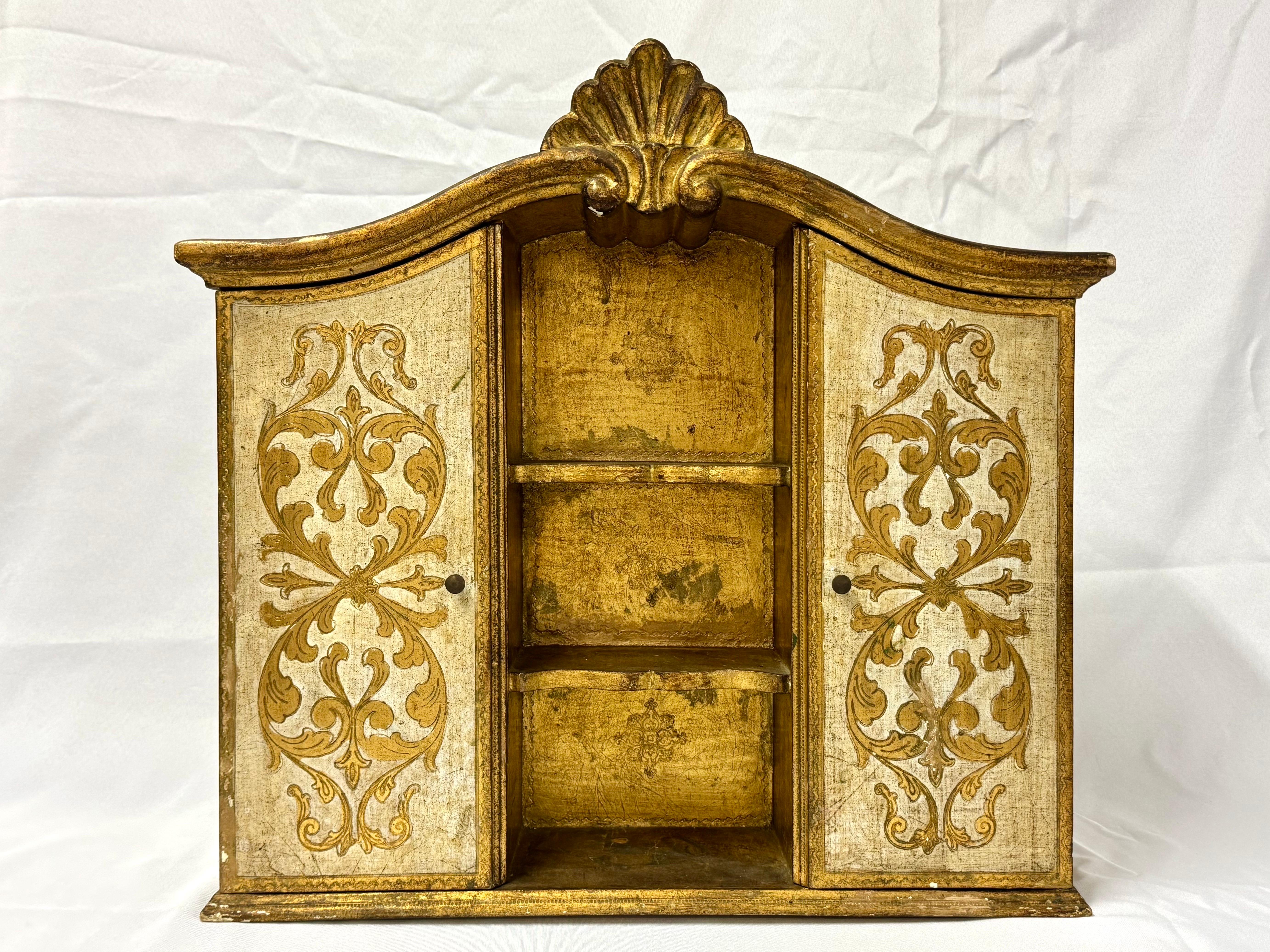 Italian Florentine Giltwood Wall Cabinet. Gorgeous decorative Wall cabibet with three shelves and two doors that open to more shelves. Perfect for in a bathroom above a latrine or for jewelry in a dressing closet.