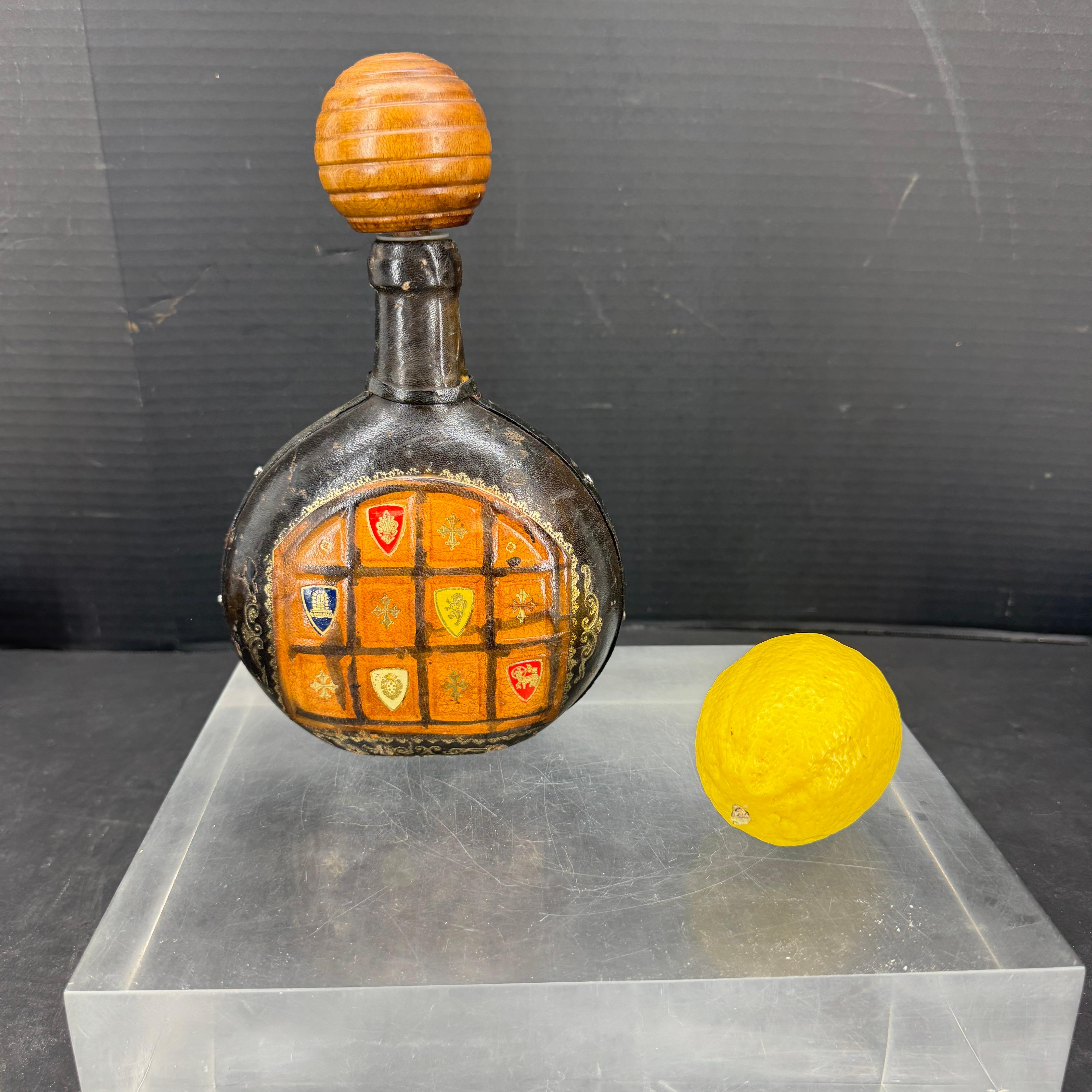 Decanter per liquori in vetro e pelle Florentine, Italia
Questo splendido pezzo Florentine con vetro presenta uno stemma in rilievo e una desiderabile patina di pelle consumata. Meraviglioso pezzo unico da aggiungere a qualsiasi collezione o da