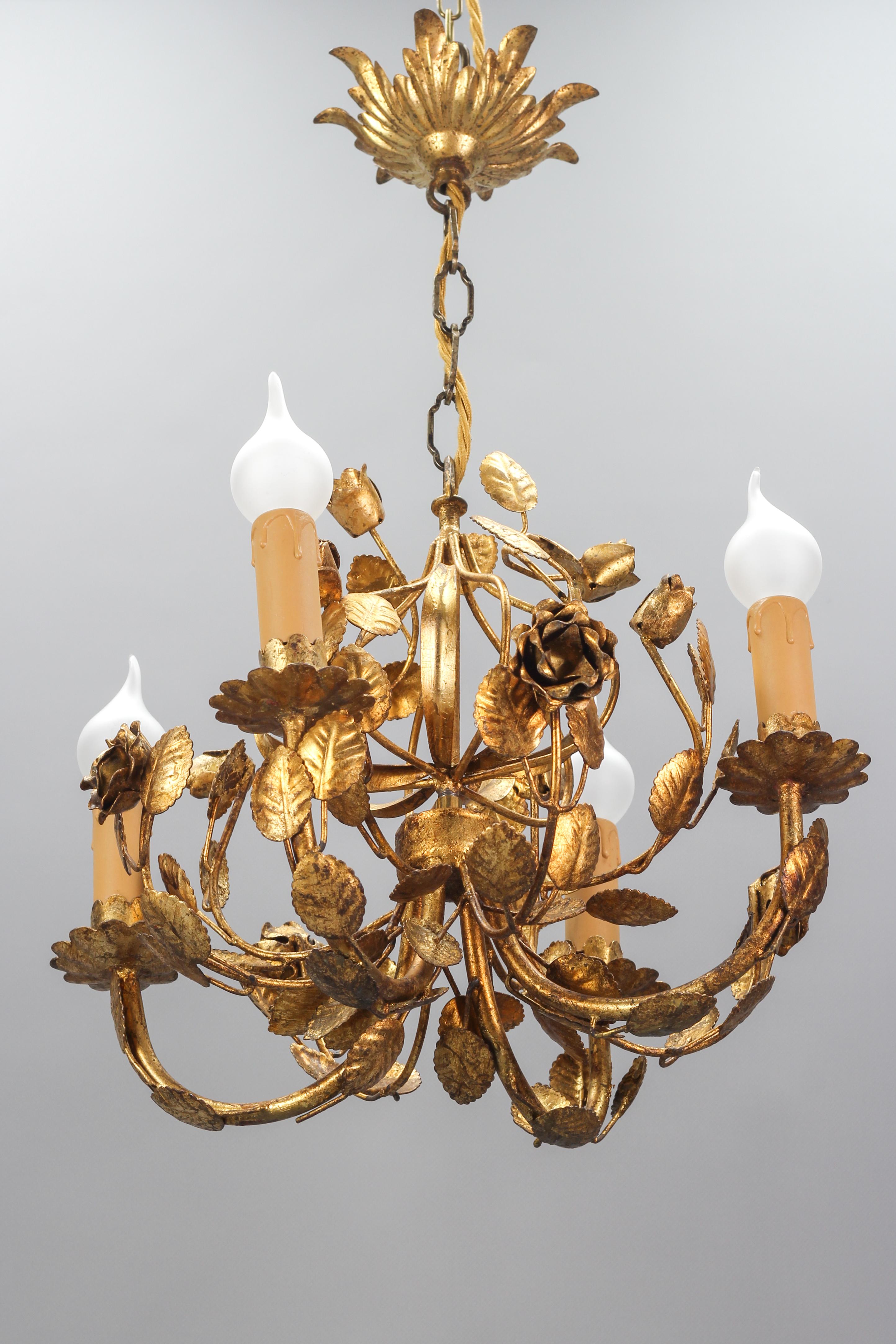 A beautiful Italian Hollywood Regency style or Florentine gilt metal four-light chandelier from the 1970s. This golden metal light fixture is adorned with charming flowers - roses and leaves. 
Four sockets for E14-size light bulbs.
Dimensions:
