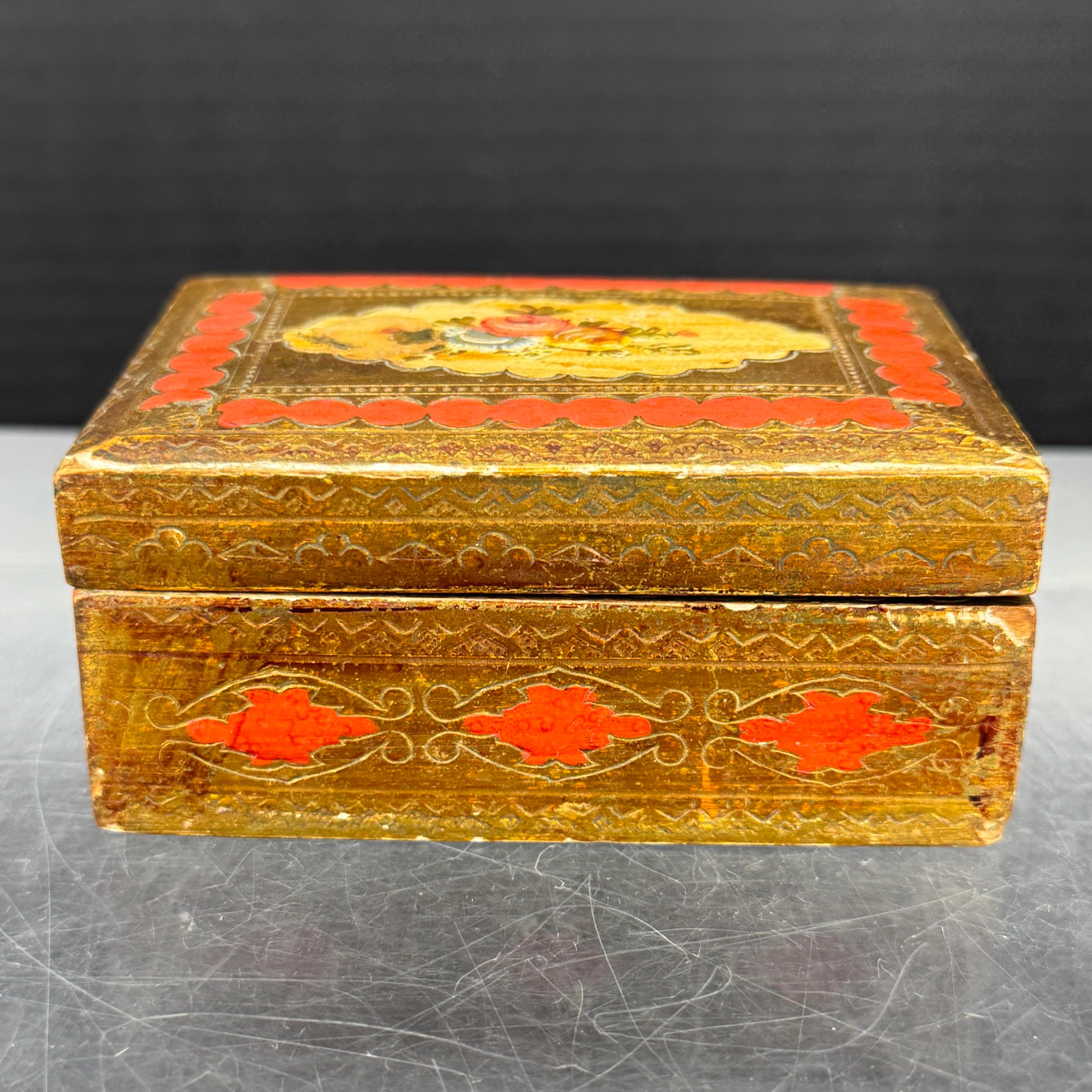 Pequeña y encantadora caja artesanal florentina italiana de mediados de siglo. Esta caja de madera dorada con flores en la parte superior se puede utilizar para guardar tus joyas favoritas, así como una pieza independiente en una mesa de centro a