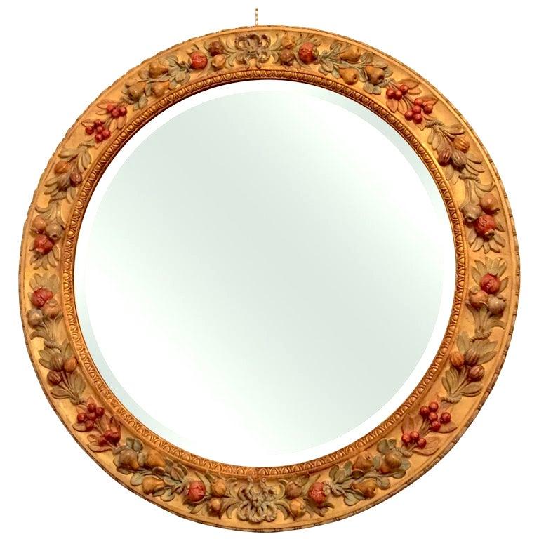 From Italy, by Chelini Firenze, a late 20th century Della Robbia Renaissance style carving circular mirror, gilt profiles and carving with fruits, vegetal motifs and ribbons, in deep relief, finished with delicate polychrome hand-painting with