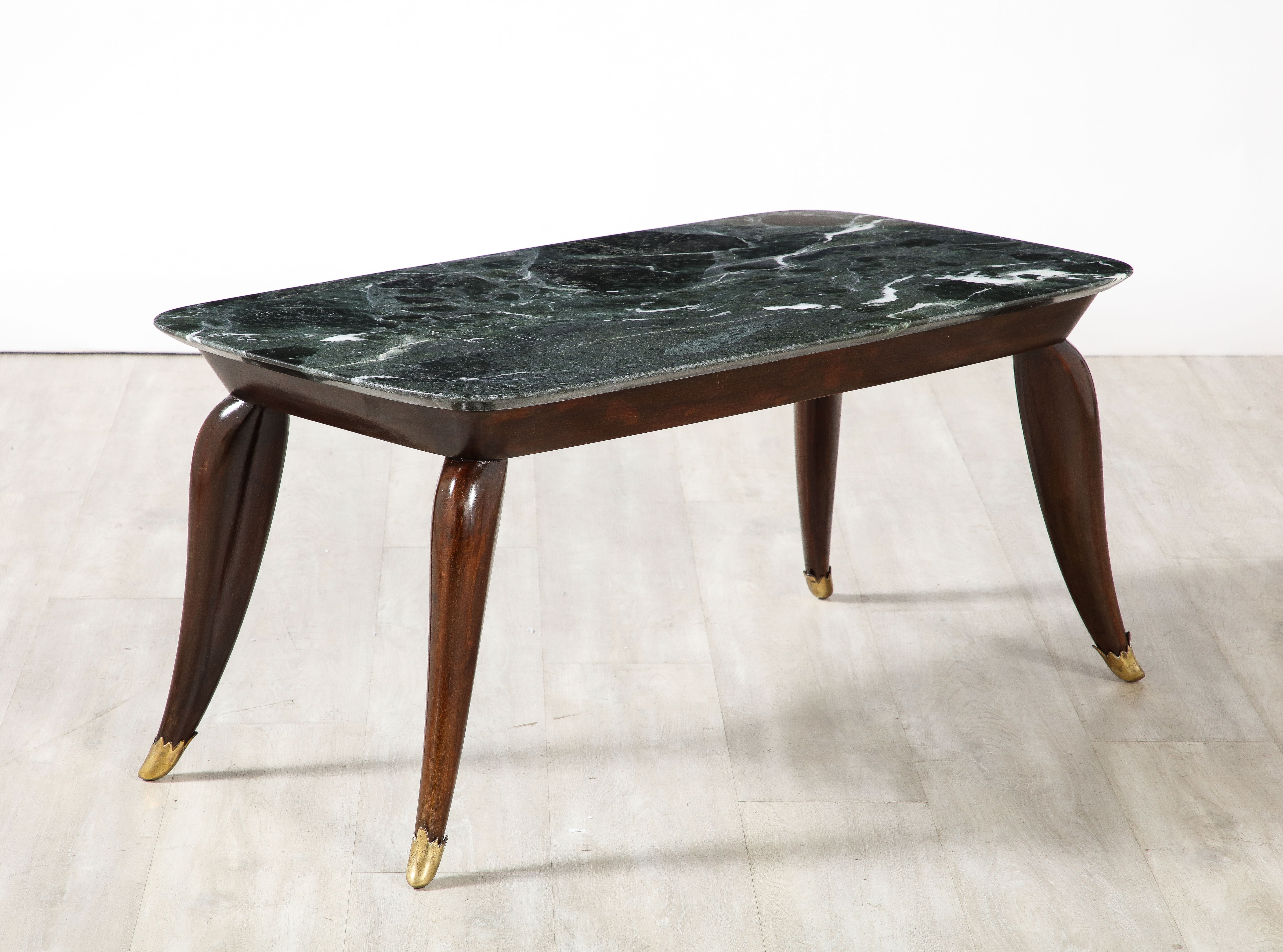 Italian Florentine walnut coffee table with Verdi Alpi marble top, circa 1940. The striking rectangular Verdi Alpi marble sits atop a wide walnut apron surround supported on elegantly splayed legs ending in fanciful brass sabot. The walnut is rich
