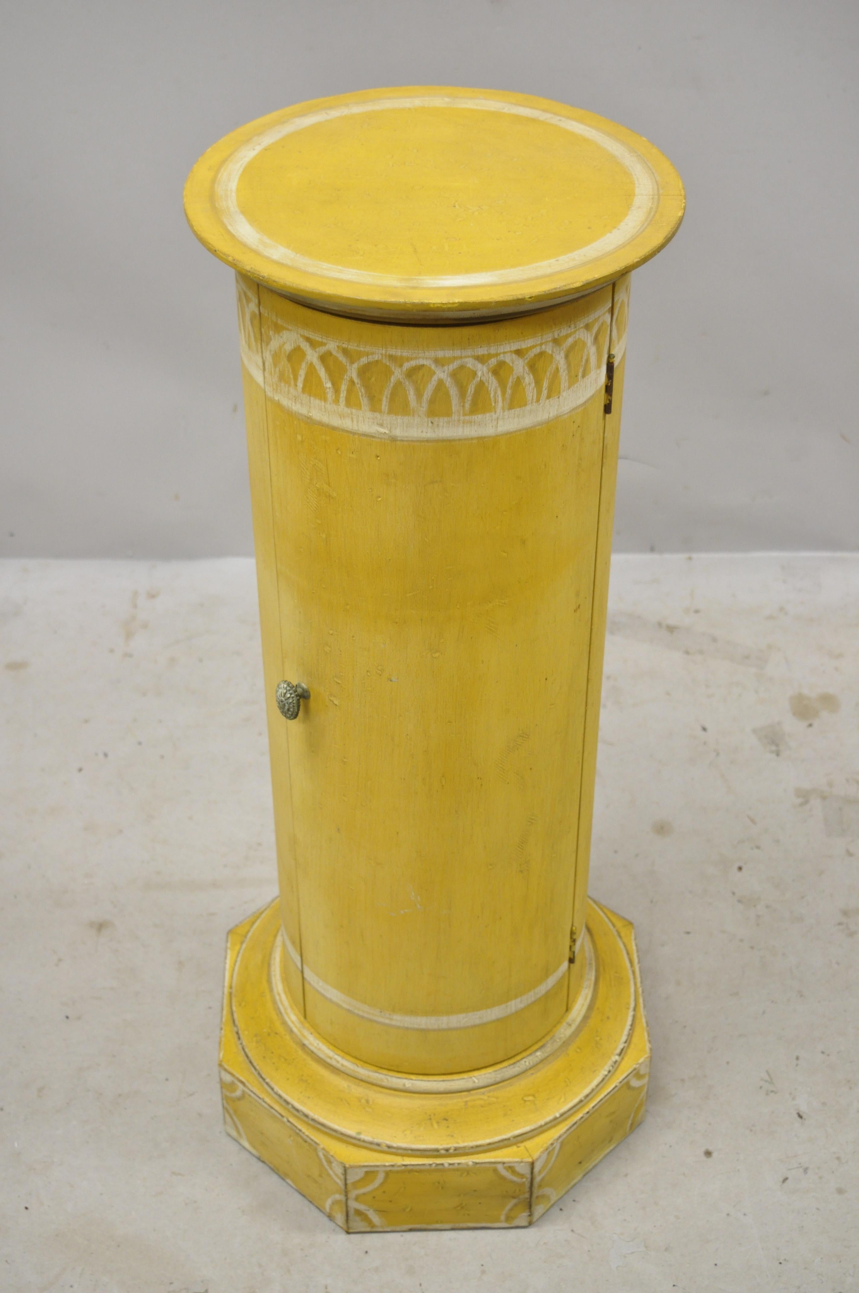 Vintage Italian Florentine yellow painted wood column form pedestal stand with door and drawer. Item features yellow and white paint decorated, round top, solid wood construction, distressed finish, 1 swing door, 1 drawer, very nice vintage item,