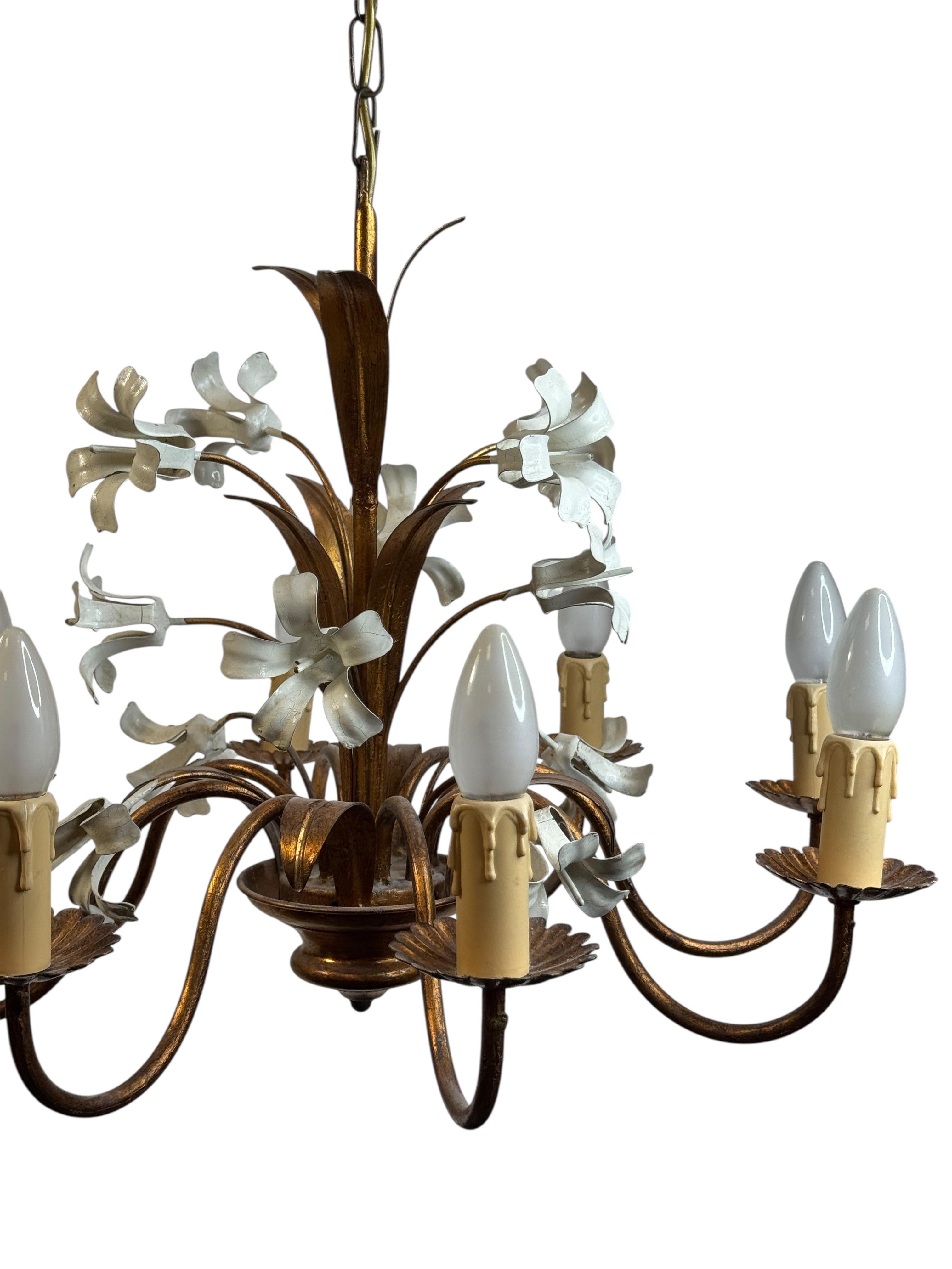 Este candelabro de flores de tole dorado de mediados de siglo de la Regencia de Hollywood requiere ocho bombillas candelabro europeas E14 de hasta 40 vatios cada una. Esta luz tiene una hermosa pátina y da a cada habitación un toque ecléctico.