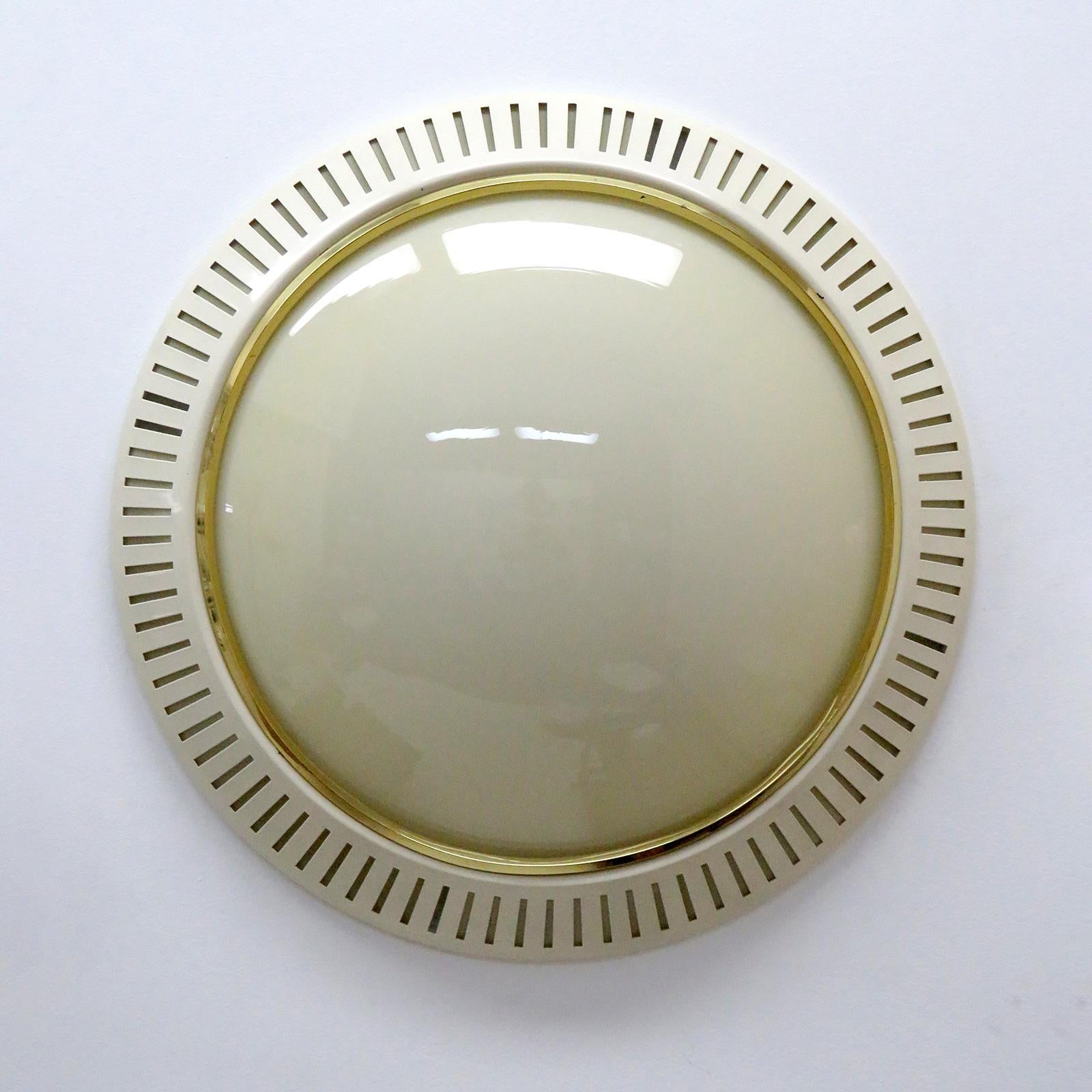 Wonderful large-scale flush mount with an beige colored glass diffuser held by a perforated eggshell colored metal enclosure with brass ring, can be used as wall or ceiling light.