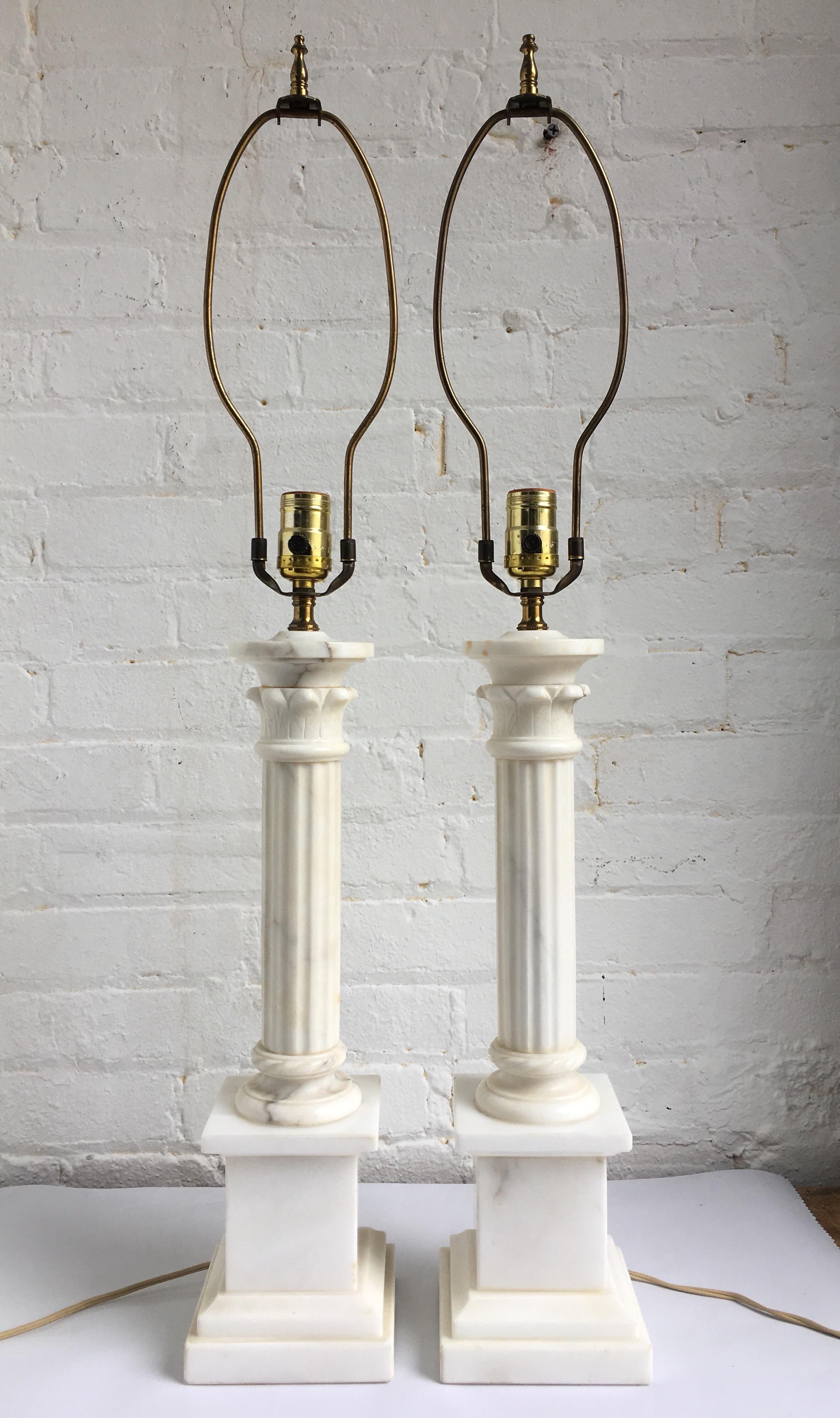 Pair of warm white marble carved column table lamps with square plinth bases. Italy, circa 1950. Lamp shades not included. 

Measures: 32.5 Inches high to harp.
21.5 Inches high to socket.