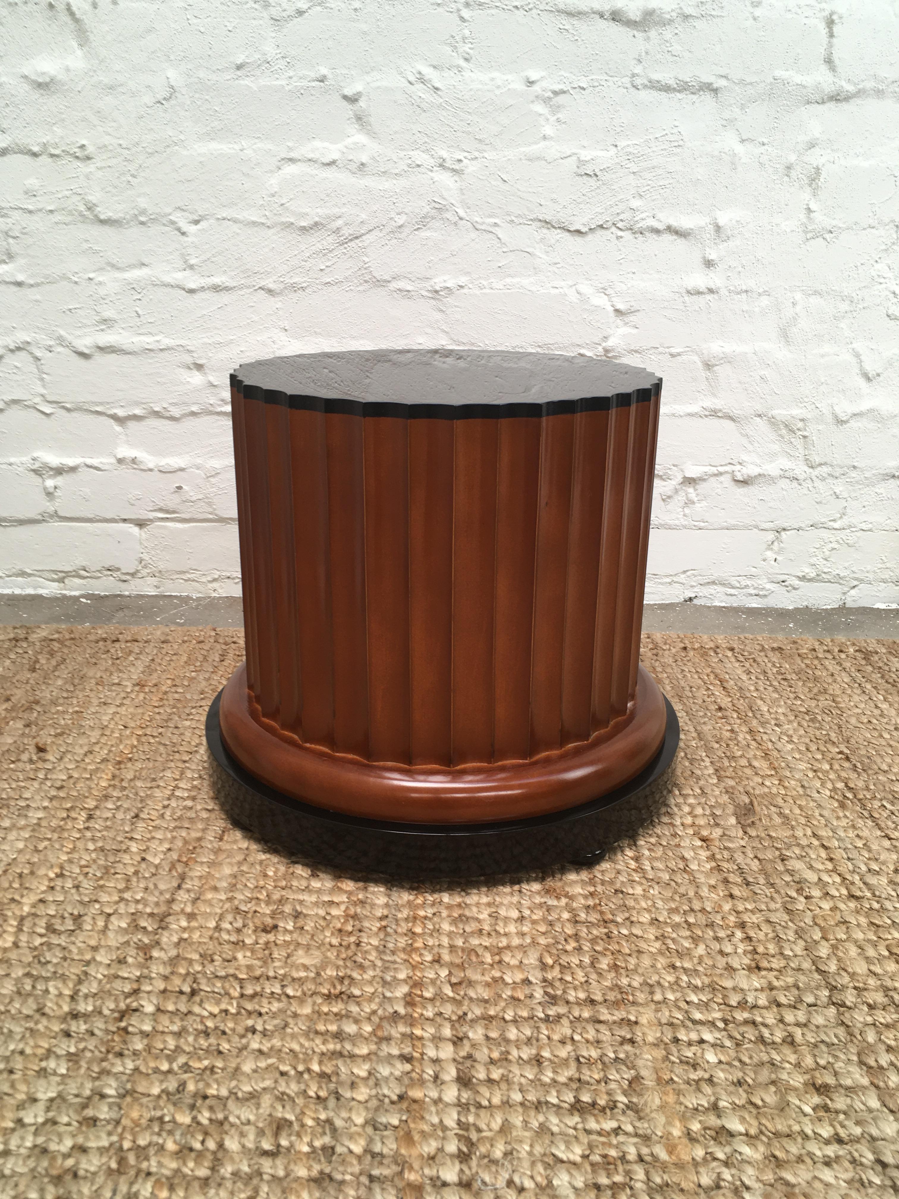 A midcentury pedestal in the form of a short, fluted Doric column. Consisting of softwood timber with a walnut finish, a black lacquered top and base, sitting on bun feet. Likely dates from the 1970s, Italian. 

An excellent plant stand, shop