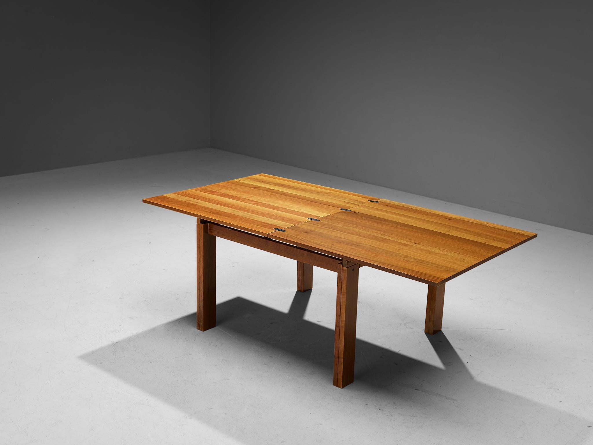 Dining table, walnut, metal, Italy, 1970s.

This pragmatic table has a folding system, meaning that this piece can easily be transformed into an extended version to enjoy a larger example. The overall appearance of this table is clear, geometric,
