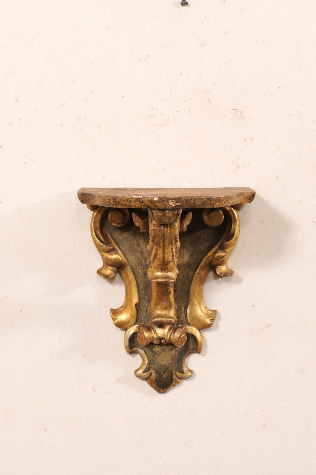 Eine italienische Wandregalhalterung aus geschnitztem Holz aus der Mitte des 20. Jahrhunderts. Dieses architektonische Vintage-Stück aus Italien wurde von Hand in ein Motiv aus Blattrollen geschnitzt. Die Regalplatte ist an der Wandseite abgeflacht