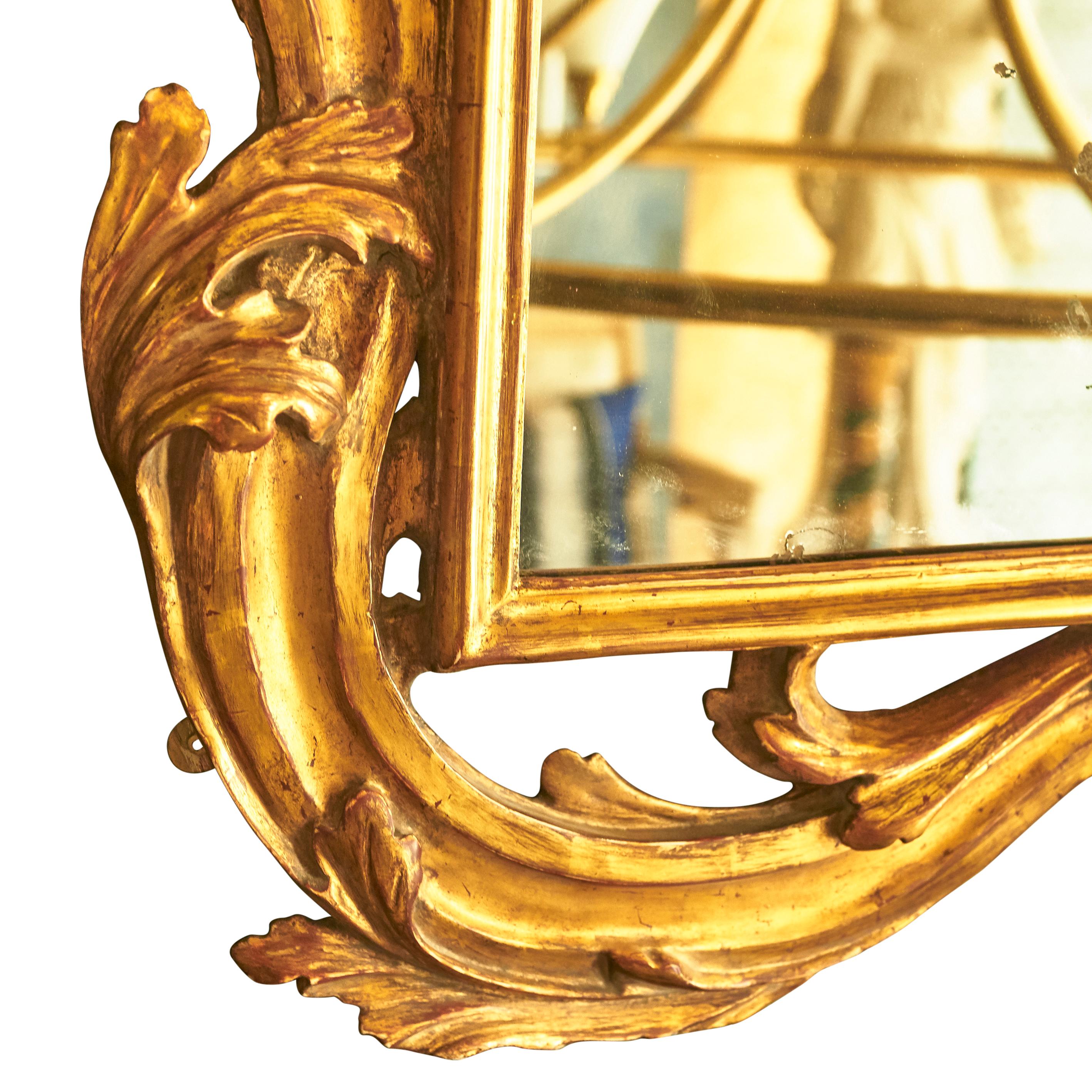 A very large landscape orientated giltwood mirror, with deeply carved foliate frame around a rectangular border, from Tuscany, circa 1770.
The original mirror plate with some patination, as seen in the images. The giltwood frame with  some