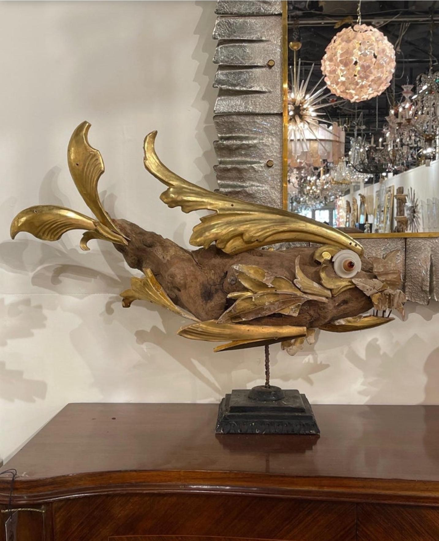 A fabulous large Italian folk art fish sculpture. Hand-crafted in the 21st century using found 18th and 19th century architectural fragments and decorative antique / vintage elements, including driftwood, shell, and carved giltwood, displayed on a