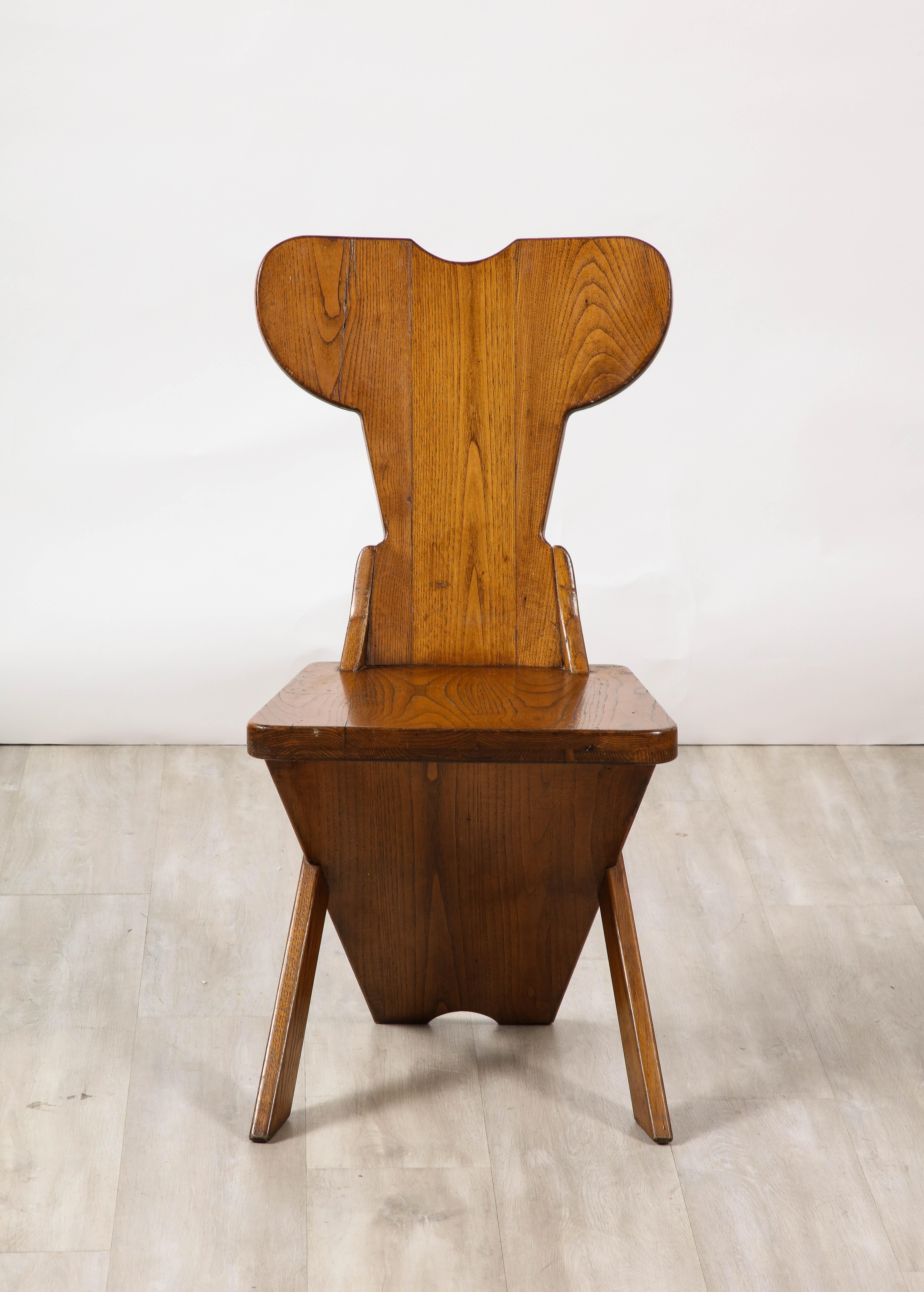 A wonderful and charming set of four dining or side chairs, displaying  traditional artistic craftsmanship, combining folk with modernism, geometric forms and practical minimalism.  The chairs are made in solid oak, with angled seats and carved