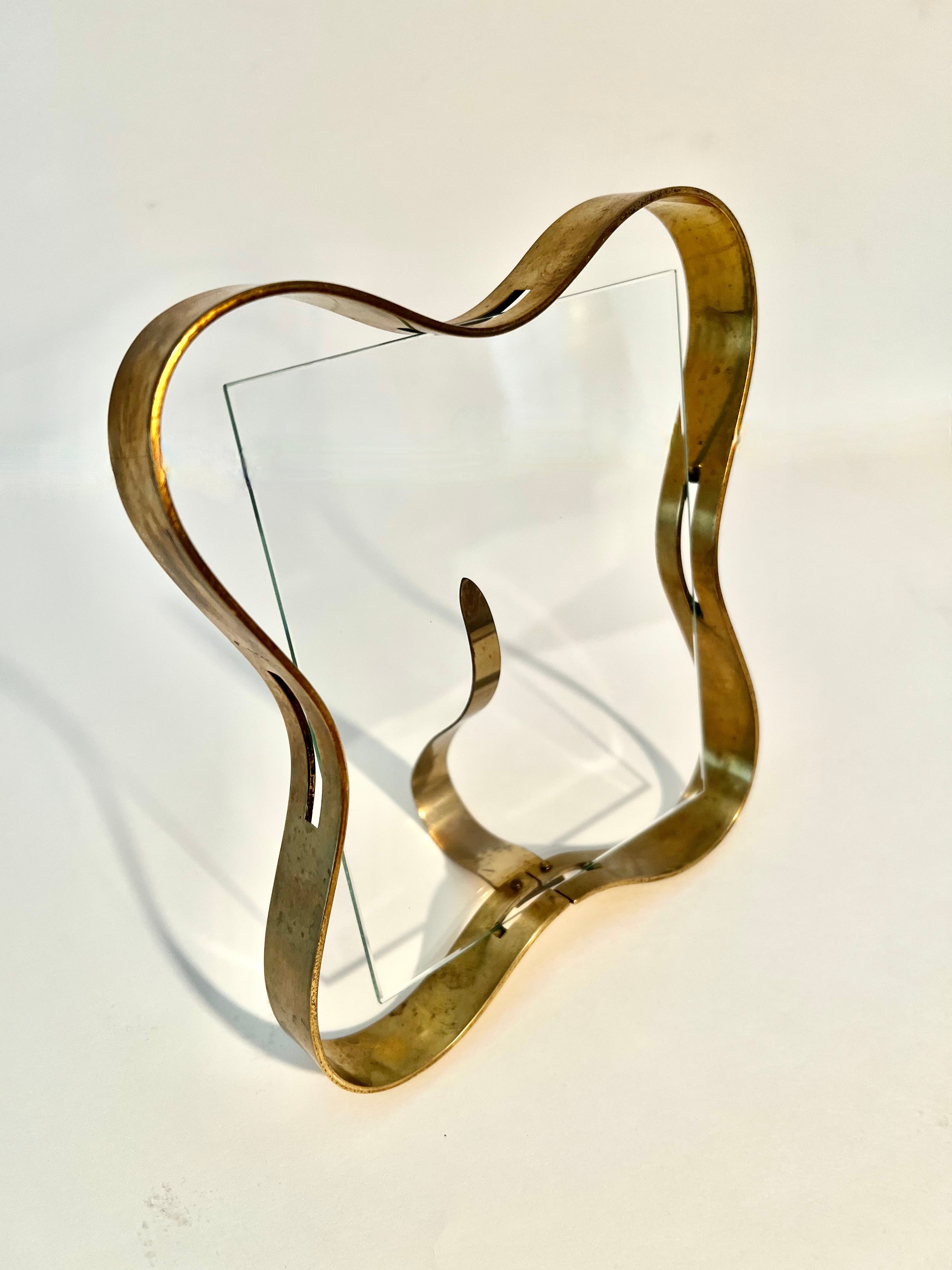 Fontana Arte Solid Brass Picture frame with a uniquely designed support, that also is used as the piece that hold the image agains the glass.

Designed in the 60s, a true Mid-Century Modern piece. A compliment to many places from on a desk or work