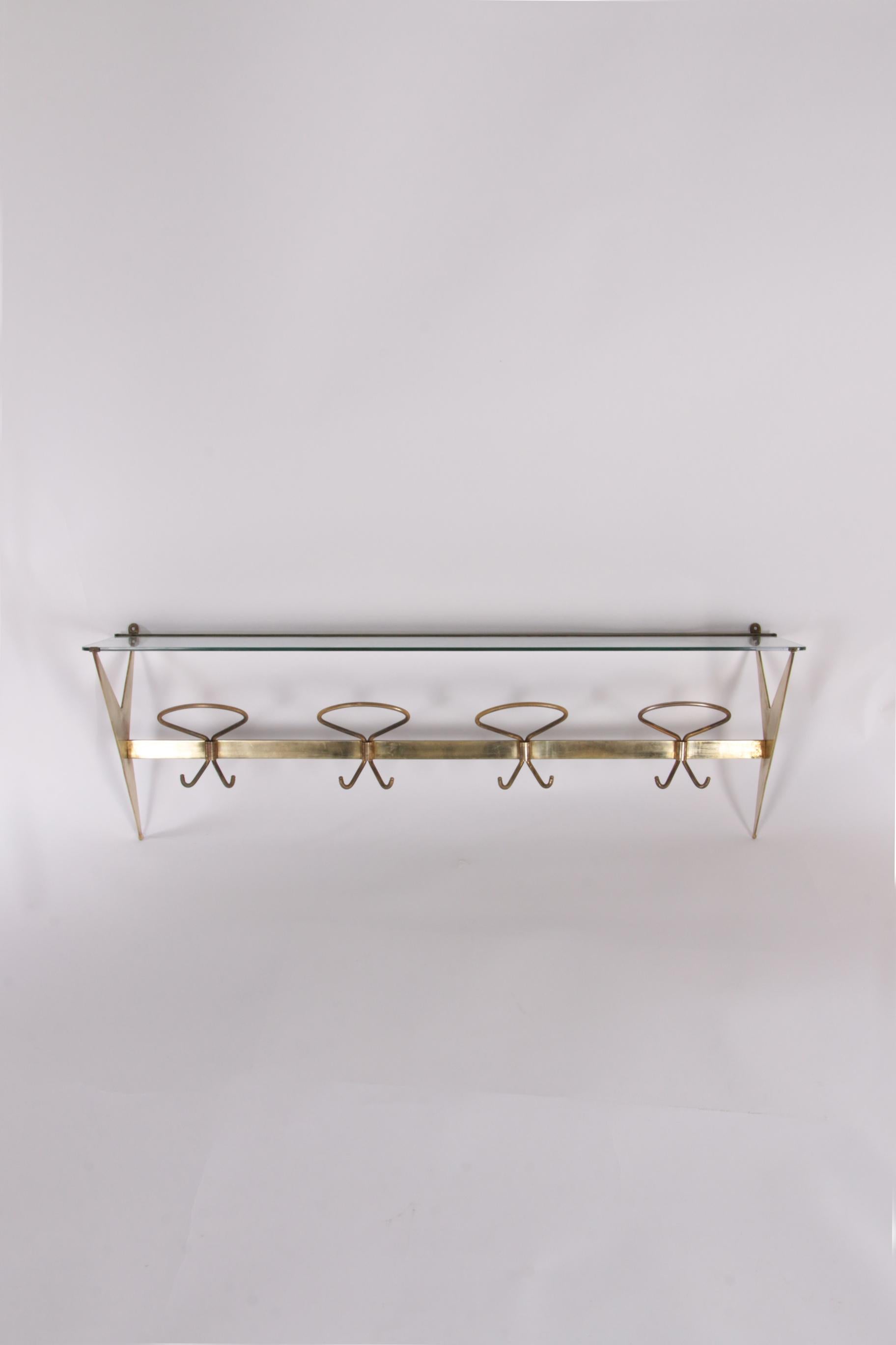 This is a coat rack made by Fontana Arte in Italy. A beautiful example of elegant design.

The coat rack was produced around the 1950s. The frame is made of brass with a glass parcel shelf to store your hats, caps and other items. The coat rack has