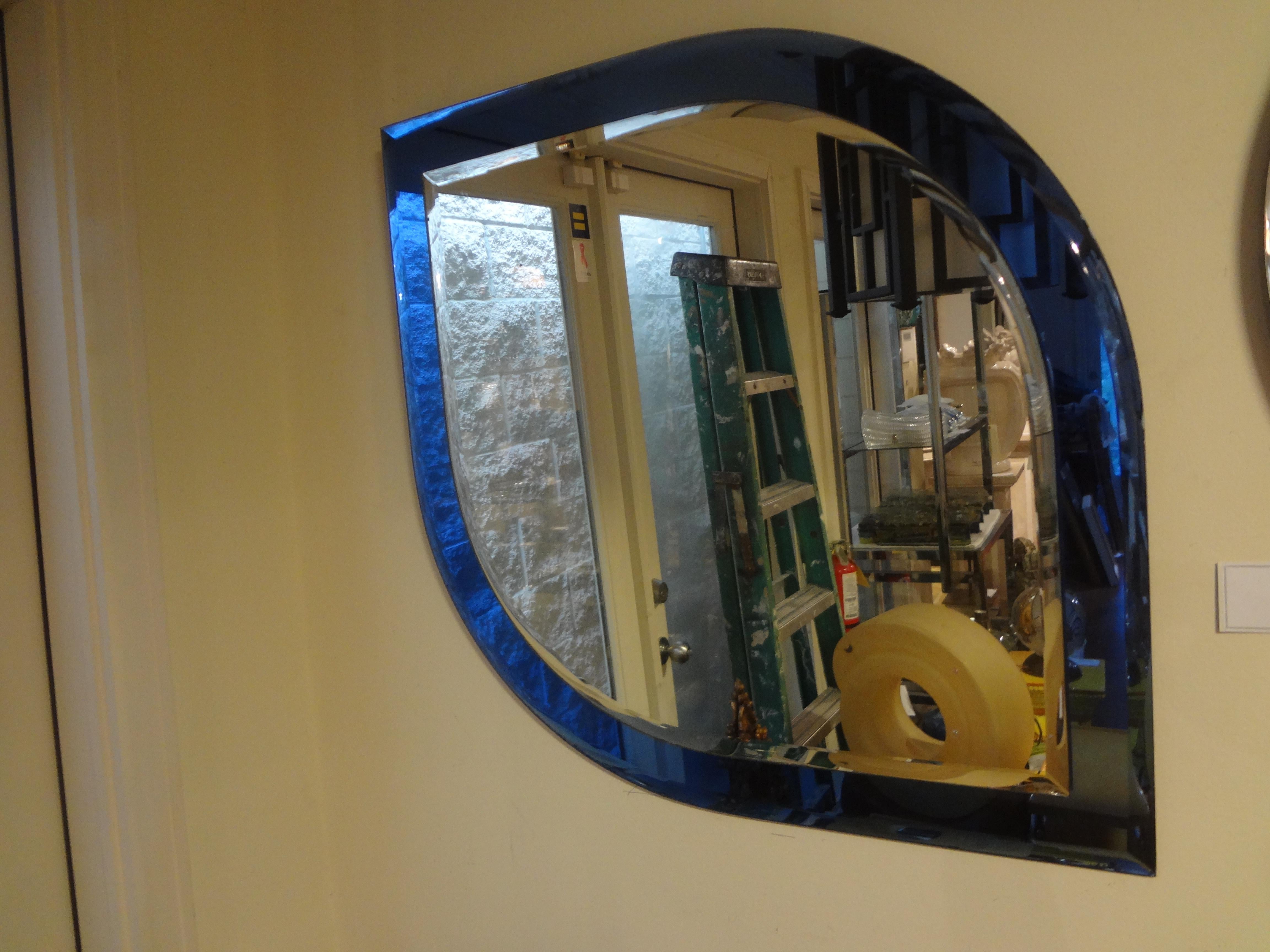 Italian Fontana Arte inspired blue mirror.
This stunning unusually shaped Italian modern blue mirror has a deep blue border with a silver beveled mirror center.