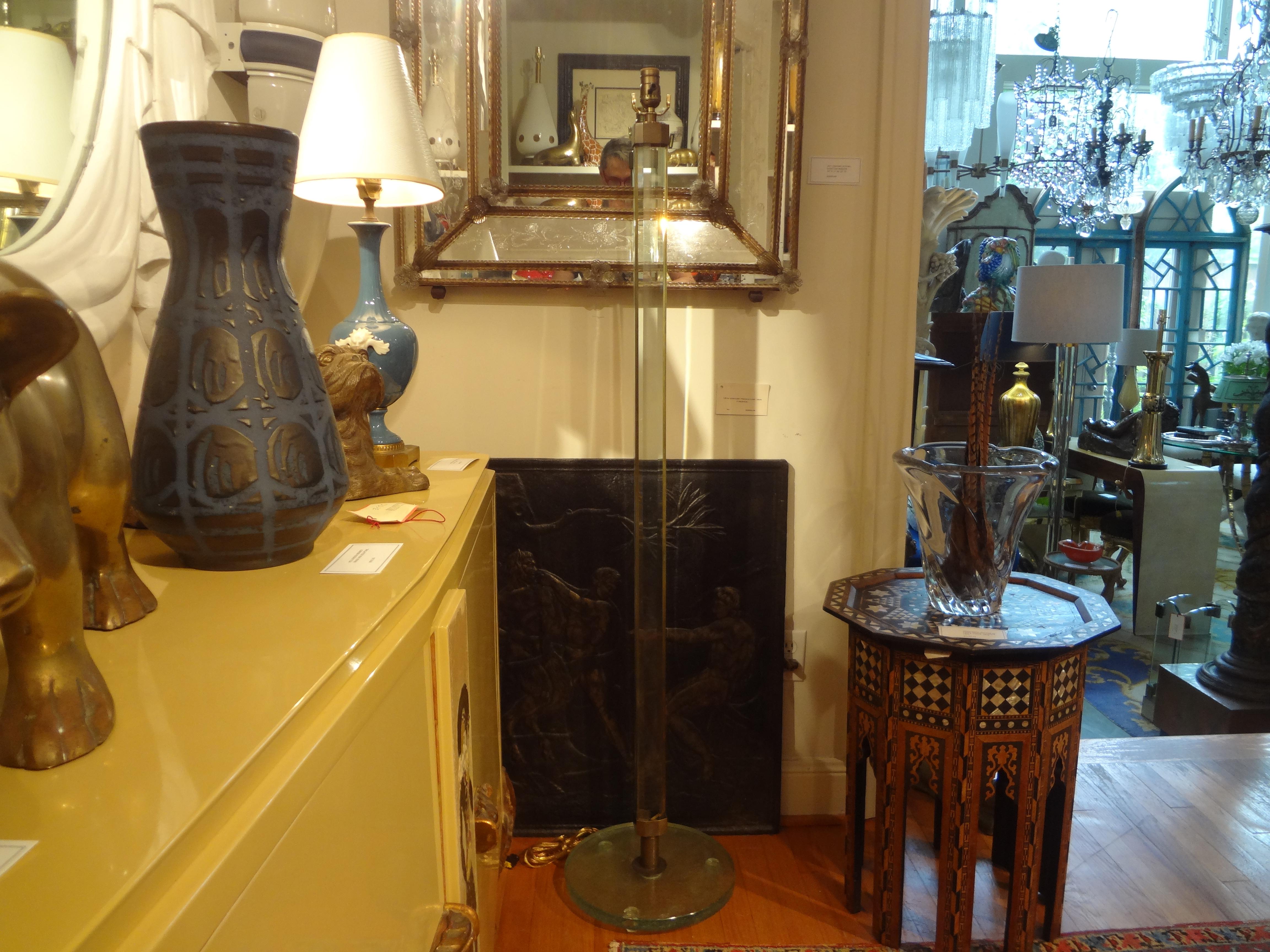 Italian Fontana Arte Attributed Glass And Bronze Floor Lamp.
This stunning Italian modern Max Ingrand For Fontana Arte attributed glass and brass floor lamp is executed of two thick pieces of glass with bronze between them on a thick round glass