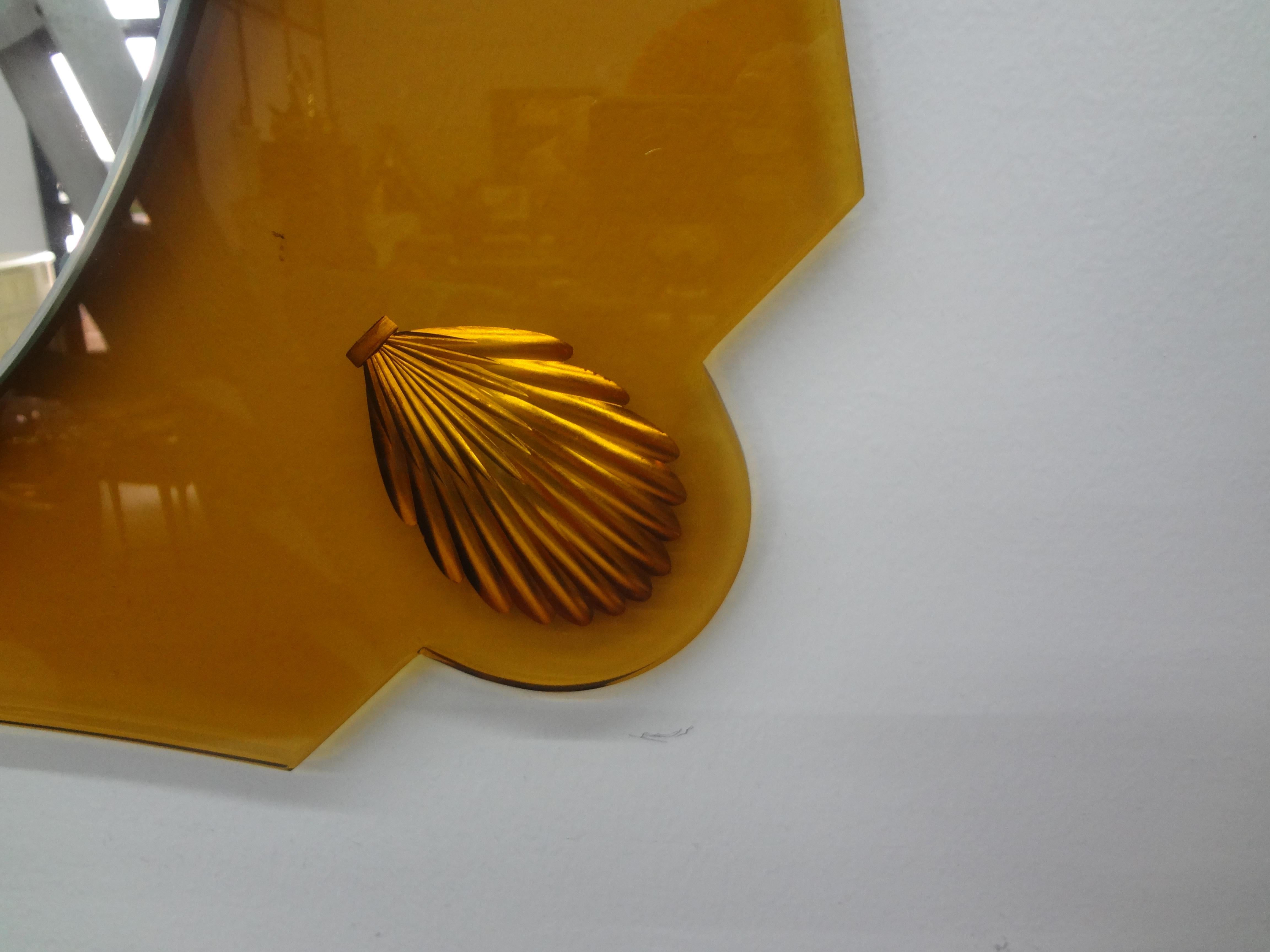 Miroir italien de style Fontana Arte jaune d'or.
Ce superbe miroir italien du milieu du siècle, inspiré par Pietro Chiesa, est composé d'un verre jaune/doré de forme inhabituelle, avec des coquillages dorés gravés dans chaque coin et un miroir