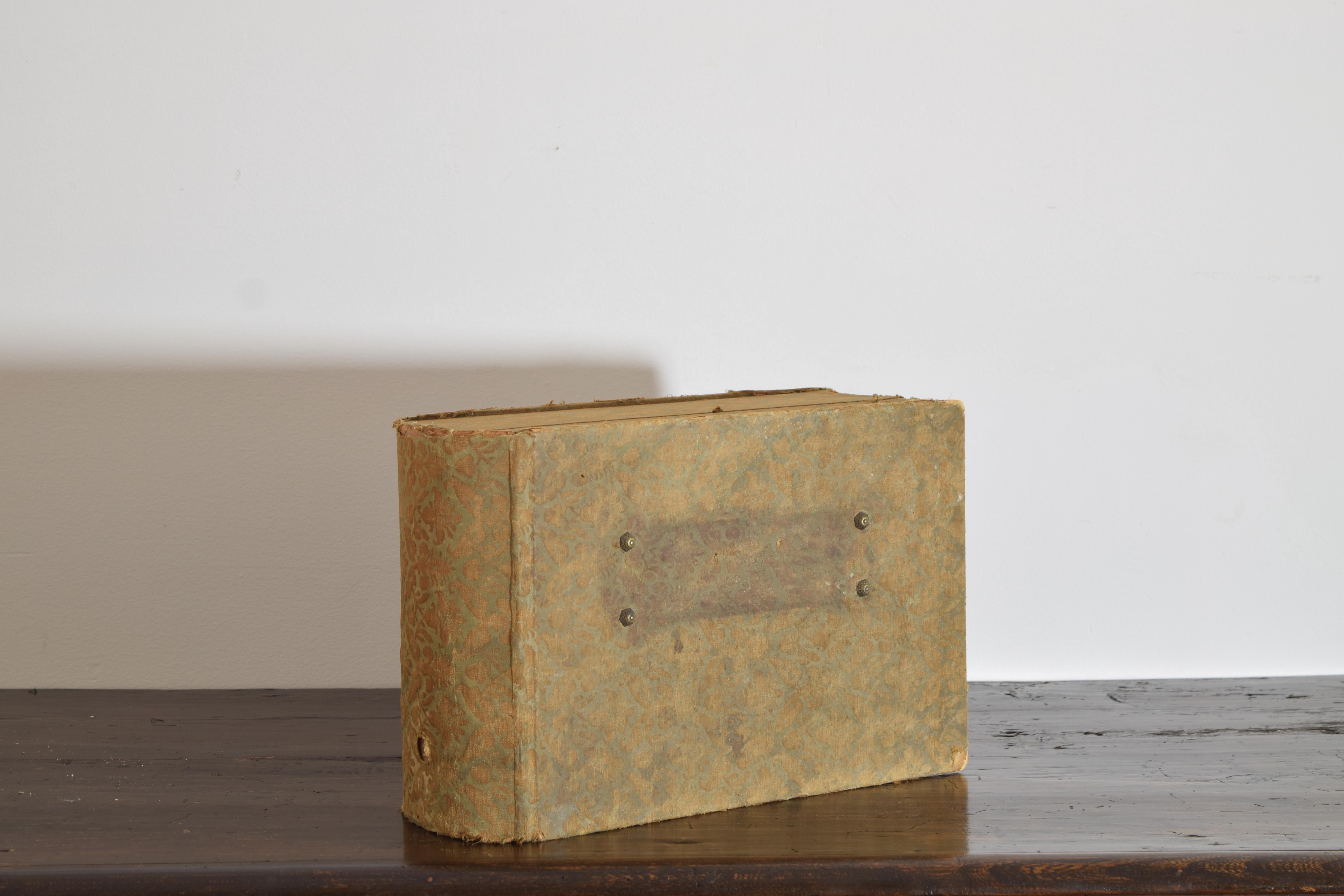 en forme de livre, avec un couvercle à charnière s'ouvrant pour révéler un espace de rangement intérieur rembourré, sans plaque signalétique (vraisemblablement en laiton).
