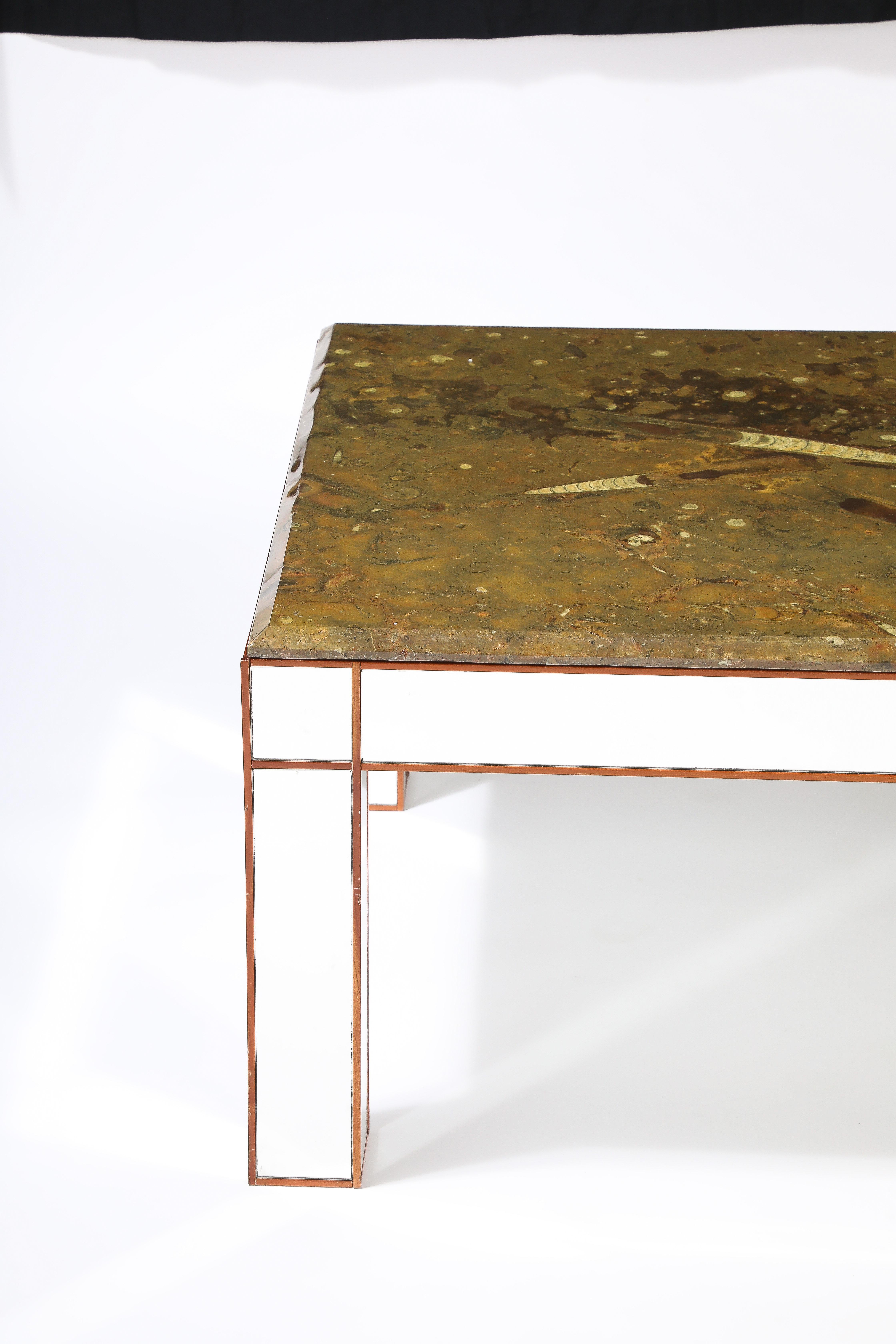 An exceptional Italian modernist fossilized marble cocktail table.  The large polished marble top containing embedded ammonite and orthoceras fossils dating back to the Pre-historic era. The quantity and coloration of the fossils in this marble is