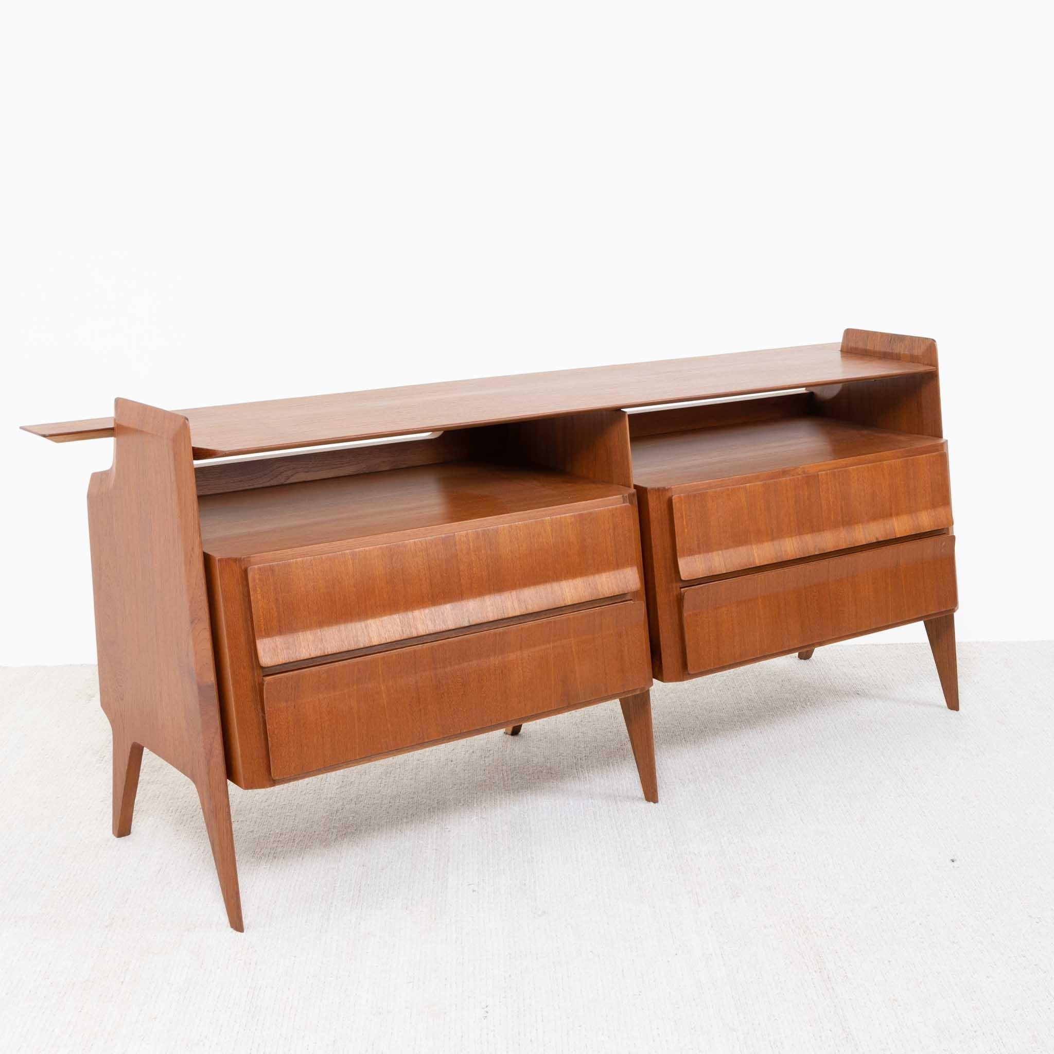 Italian mid-century sideboard featuring four drawers and a large full-length shelf that slightly protrudes over the sides, providing an intriguing profile. Crafted from solid and veneered teak, the surface boasts a matte polish. The drawer fronts
