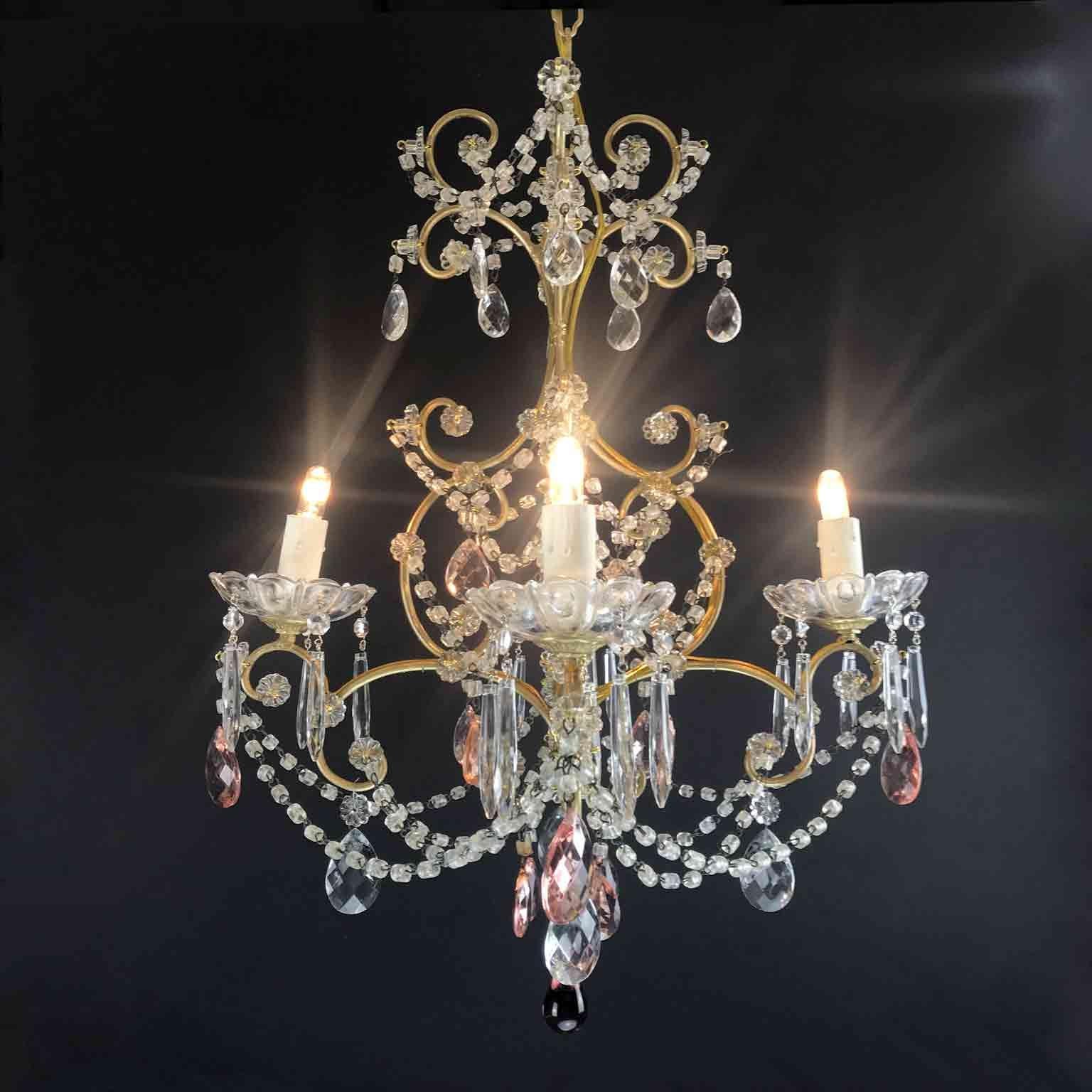 From Italy, a small romantic four-armed chandelier with a gilded brass cage shaped scrolling frame with four Edison 14 lights, fully decorated with clear crystal beaded swags, warm rose color crystal drops and beaded crystal chains.
Very good
